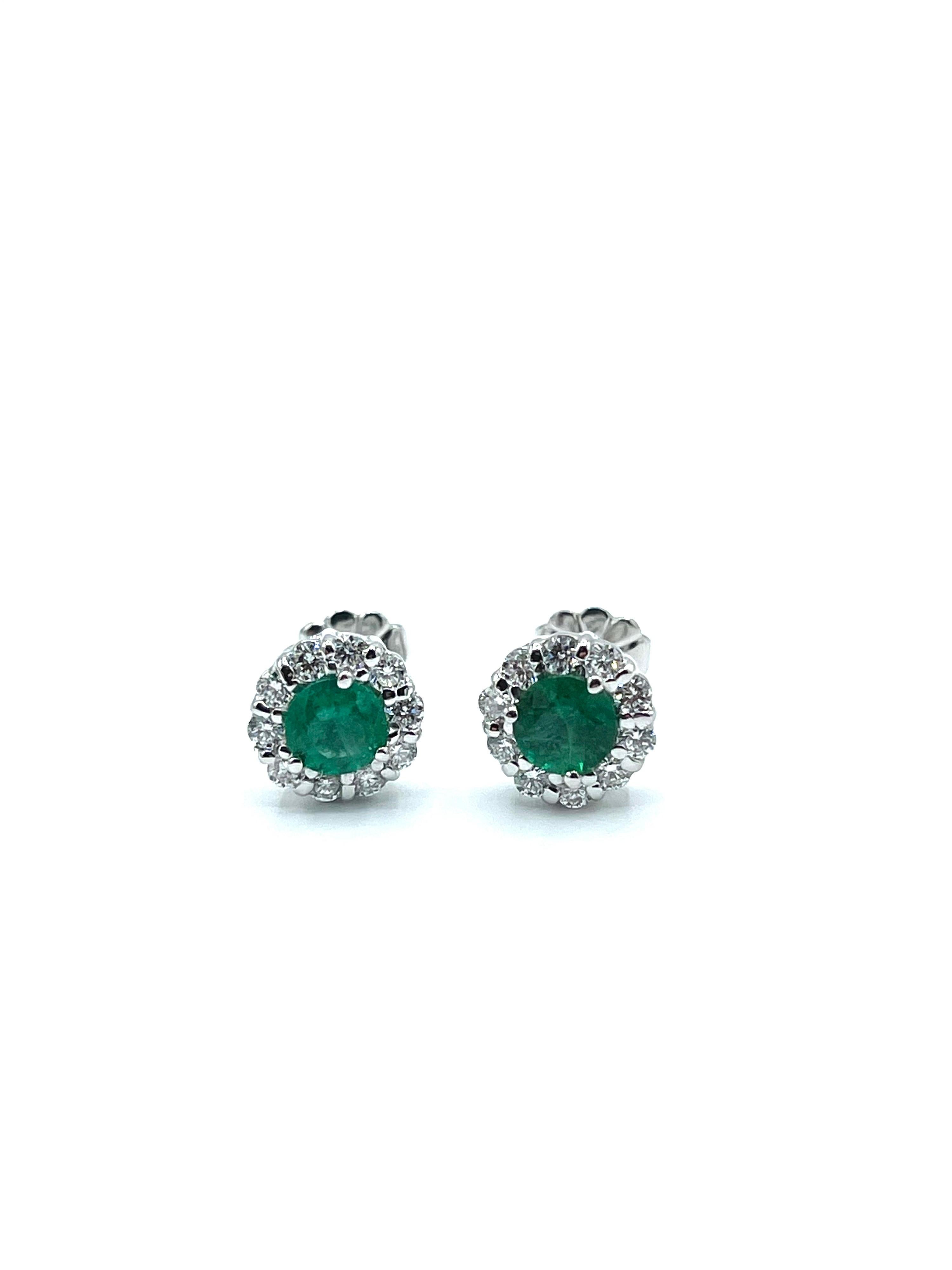 A pair of vibrant Emerald and Diamond stud earrings!  The round cut Emeralds are set in four prongs, surrounded by a single row of round brilliant cut Diamonds in 18kt white gold.  The two Emeralds have a total weight of 0.75 carats, and the 20