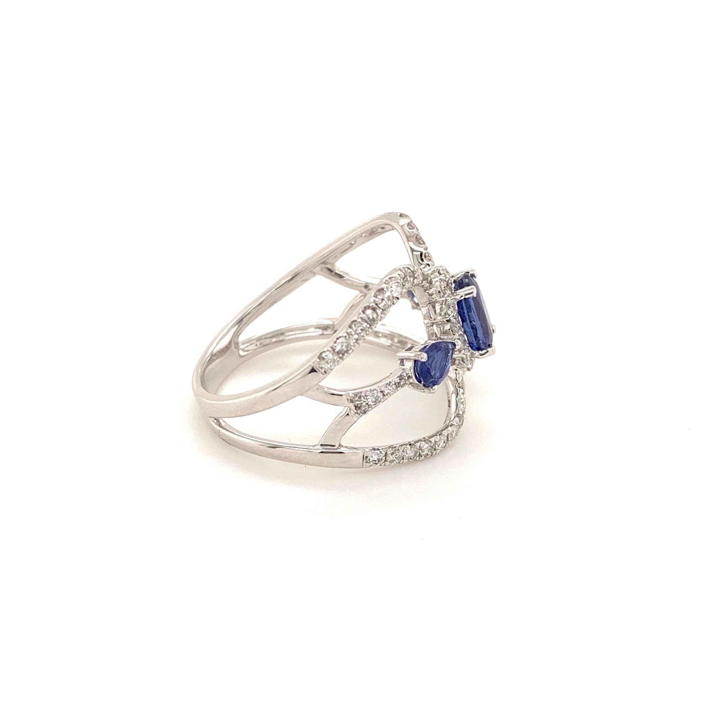 Striking design kyanite diamond ring. Royal blue, oval faceted 0.75 carat natural kyanite mounted in profile open basket with four prongs, accented with round brilliant cut diamonds with two pear faceted sapphires on the shoulder. Handcrafted