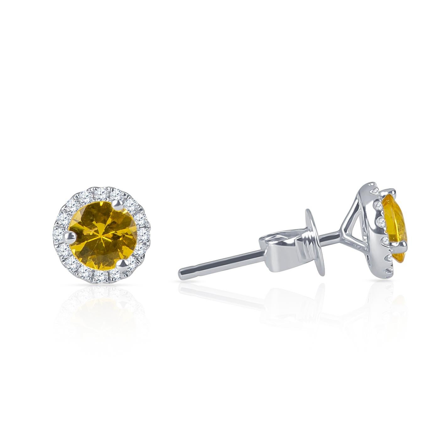 Beautiful pair of 0.75 carats total weight in fine natural round yellow sapphire stud earrings with 0.16 carats total of round brilliant cut diamonds in halo form. Stones are set in 18K white gold with friction posts and backs. 

Diamond quality: