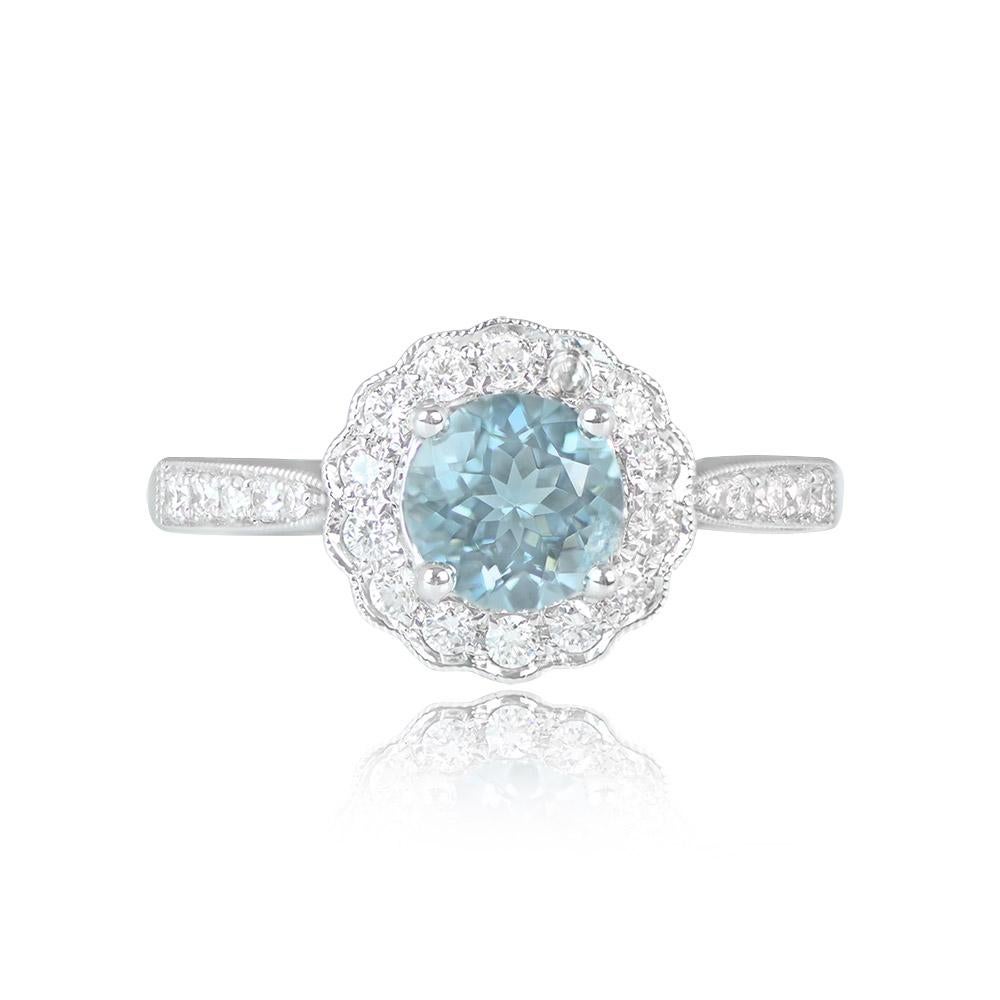 Enchanting cluster ring showcasing a natural round aquamarine weighing 0.75 carats at the center. Surrounding the aquamarine is a delightful cluster of round brilliant-cut diamonds with a total approximate weight of 0.32 carats. The shoulders are