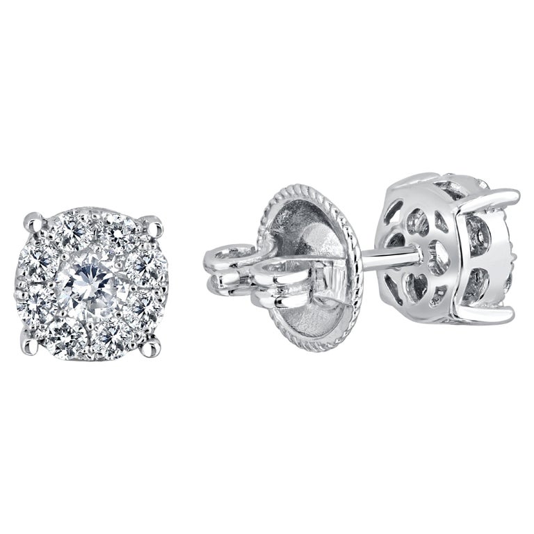 These beautiful earrings feature 0.76 carats total weight diamonds. This is comprised of each earring with a center diamond stone, surrounded by a tight halo of smaller diamonds, to give the illusion of a single large diamond. Set in 14k White