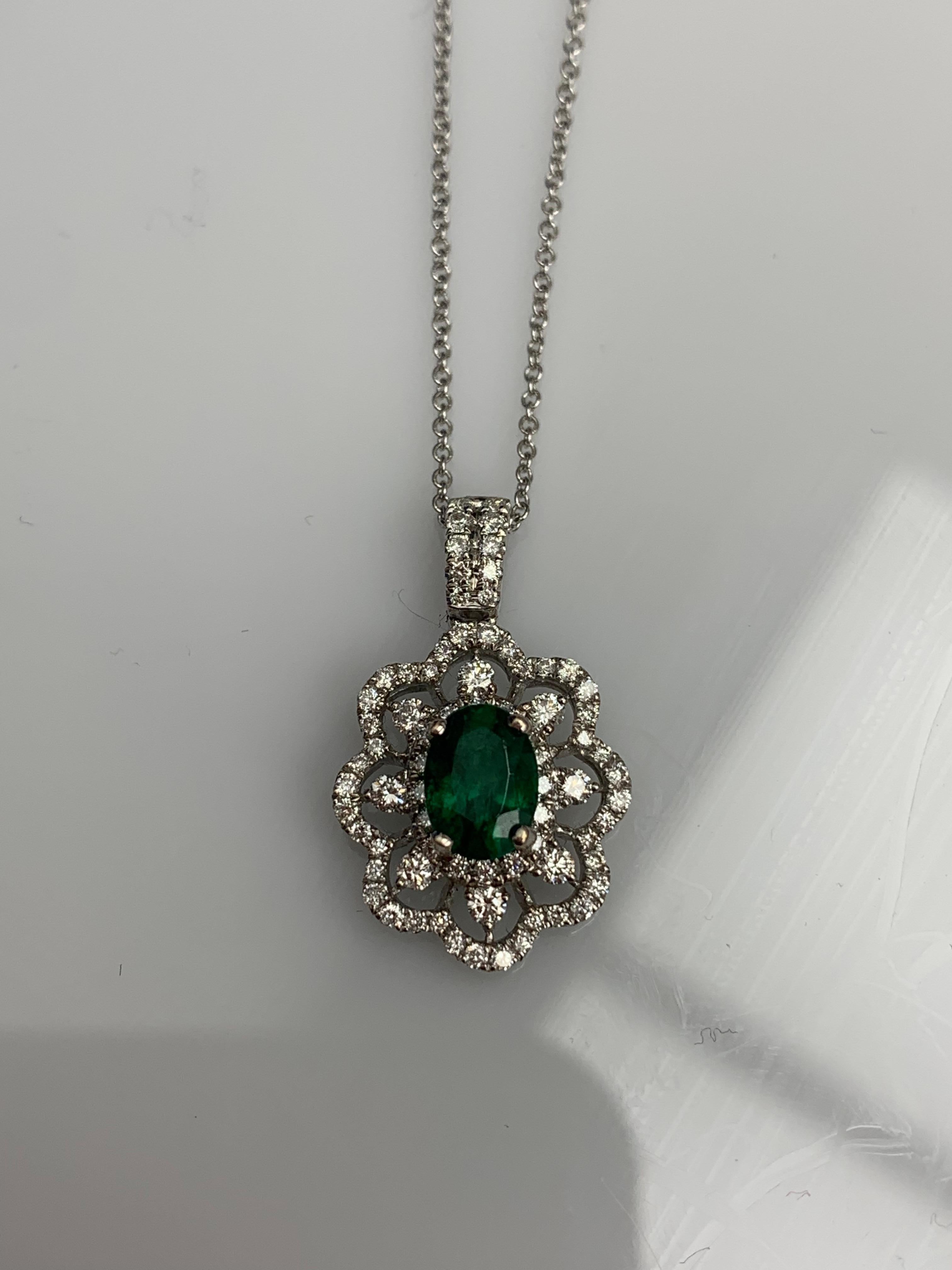 A simple floral motif pendant necklace showcasing a vibrant 0.76-carat oval cut Emerald, surrounded by 0.56 carats of 73 accent round diamonds in an open work design. Made in 18 karats white gold.

Style is available in different price ranges.