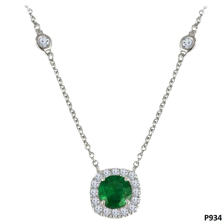 This exquisite pendant boasts a 6mm round-cut emerald at its core, weighing 0.76 carats, encircled by a halo of round white diamonds. With the halo, the overall design takes on a cushion-like shape. The combined weight of the diamonds in this