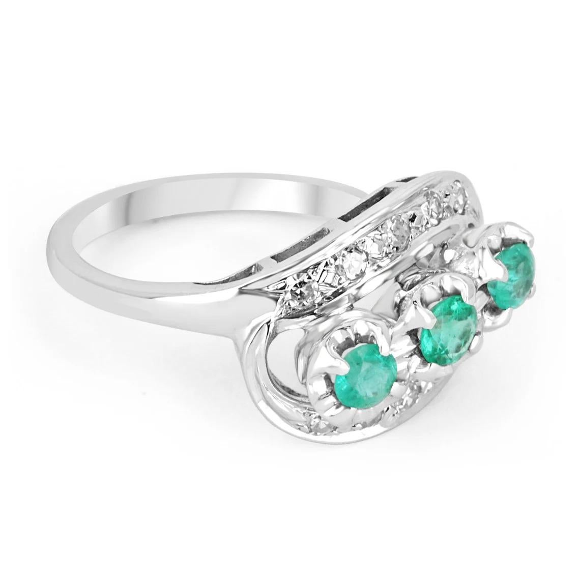 Displayed is a 0.76tcw vintage Colombian emerald and diamond ring. This is a perfect statement ring with three round emeralds. The emeralds are of good, varying quality and are handset in a 14K white gold prong setting. The bluish-green color is