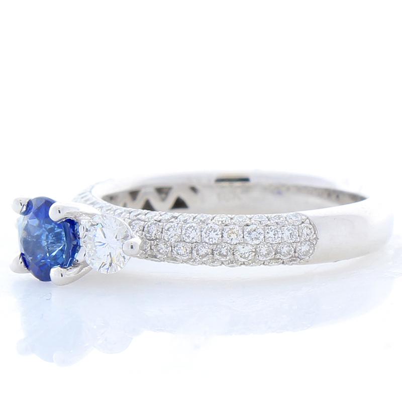Elegant and royal. This ring features a gorgeous 0.77 carat, 5.24 x 5.20 mm, vivid royal blue sapphire hugged by neighboring 0.38 carats of brilliant round diamonds. All delicately set, like a crown, above this stunning band featuring 0.53 carat