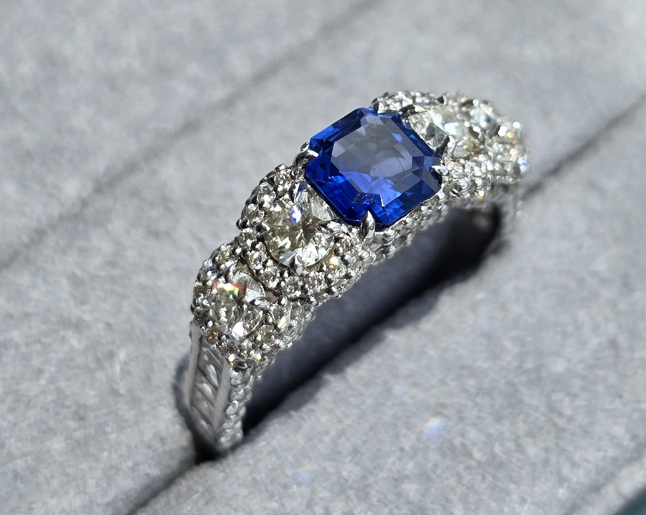 18kt white gold sapphire ring with diamonds
  
  Gold colour & karat: White gold 18kt
  Weight: 4.571 grams
  
  Set with-
  Stone type: Sapphie
  Shape: Emerald
  Carat: 0.77
  Colour: -
  Clarity: -
  
  Surrounding Stones: Diamonds
 1) Side Round