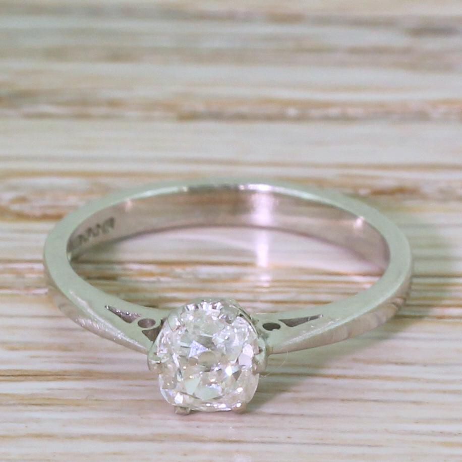 A classic old cut engagement ring. The old mine cut in the centre, weighing in at 0.78 carat, is bright and full of life. The stone, dating from the late 1800s, is secured in a modern, platinum setting, with a six claw collet leading to a tapering