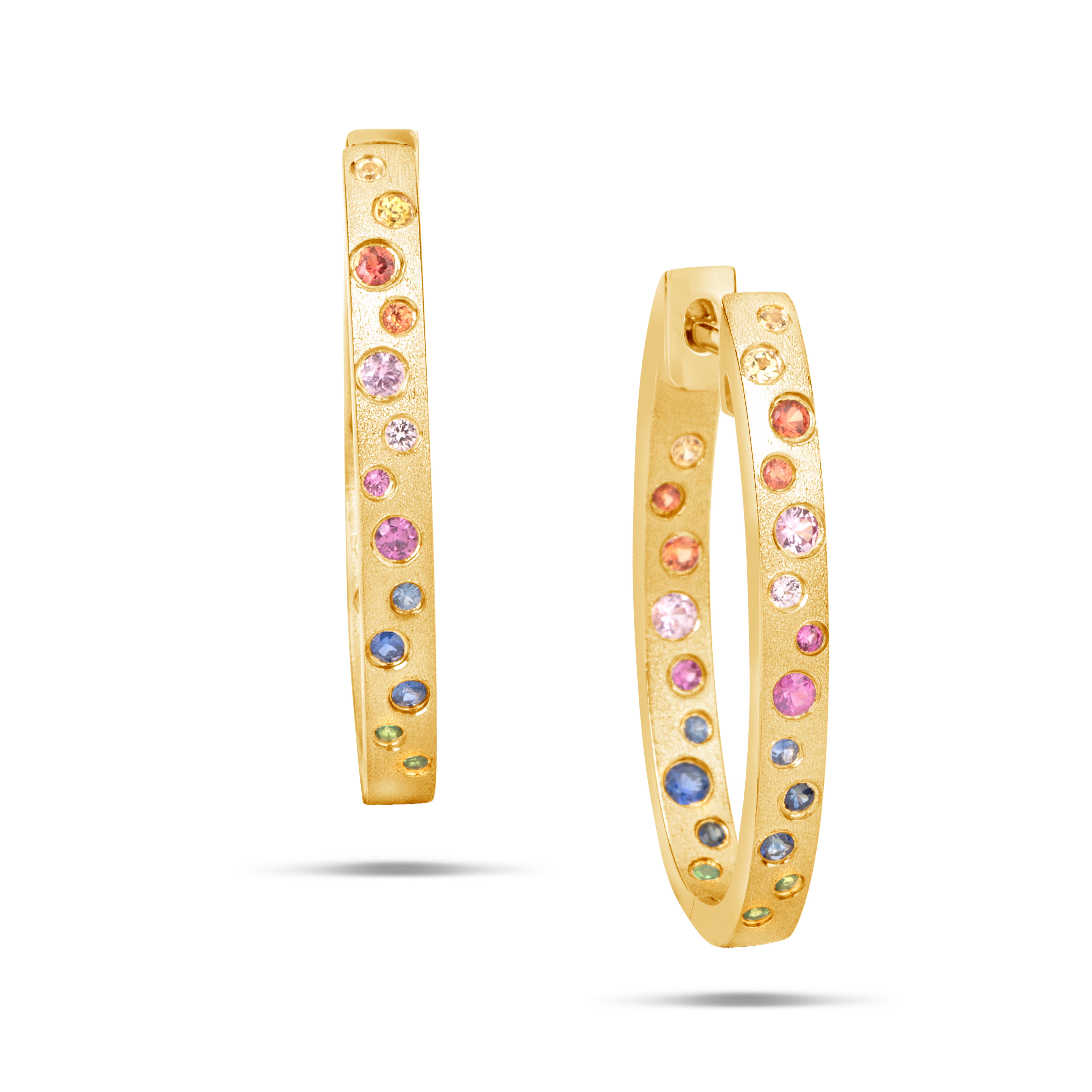 These Rainbow Sapphire and Tsavorite earrings are a stunning and timeless accessory that can add a touch of glamour and sophistication to any outfit. These Flush Set Oval Hoop Earrings contain 0.78 Carats of Round Rainbow Sapphires, Rubies and