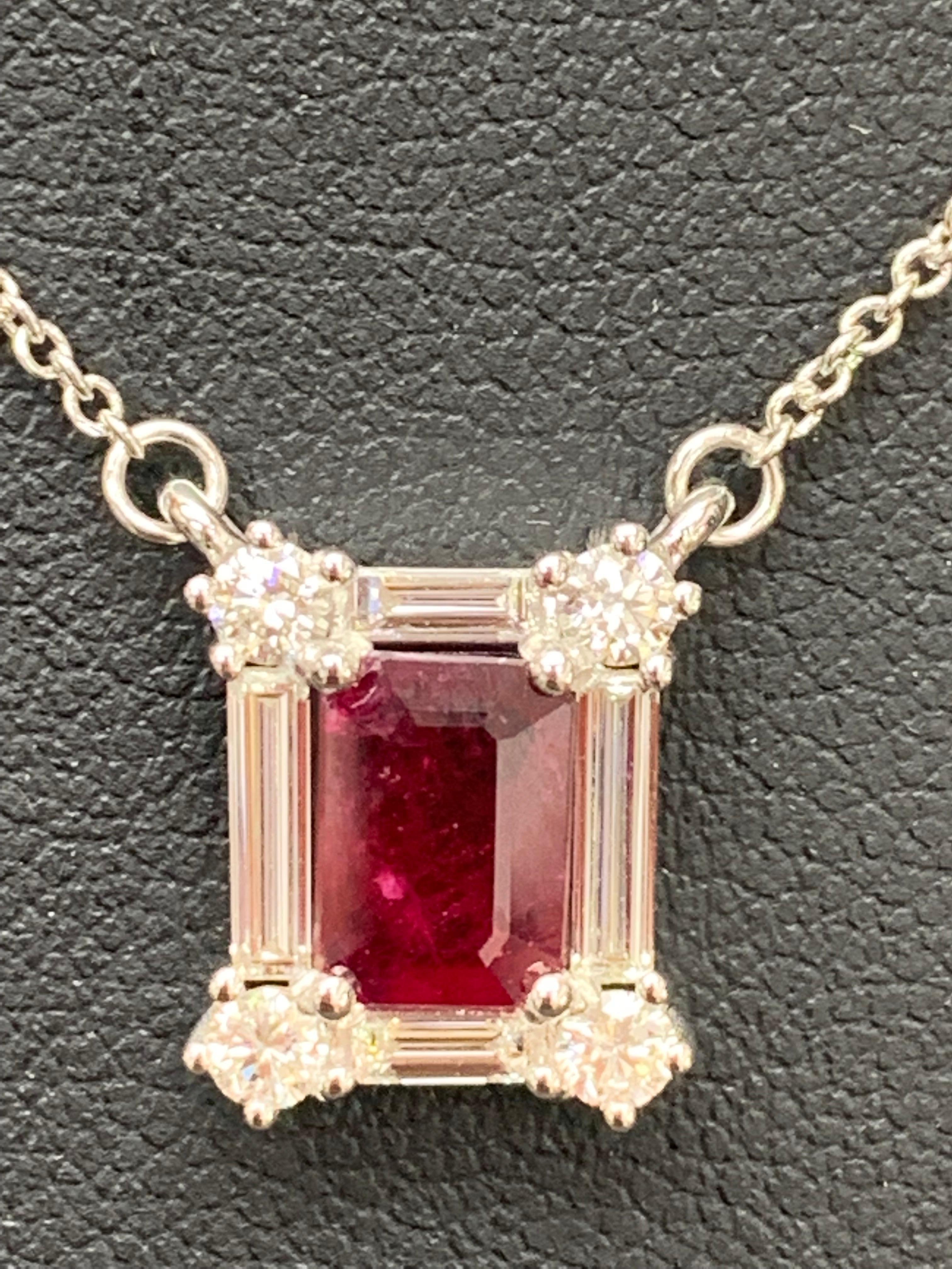 A fashionable pendant necklace showcasing a 0.79-carat emerald cut ruby. The center stone is surrounded by a row of brilliant-cut round and baguette diamonds weighing 0.63 carats total. Made in 14k white gold. Comes with a gold chain accented with