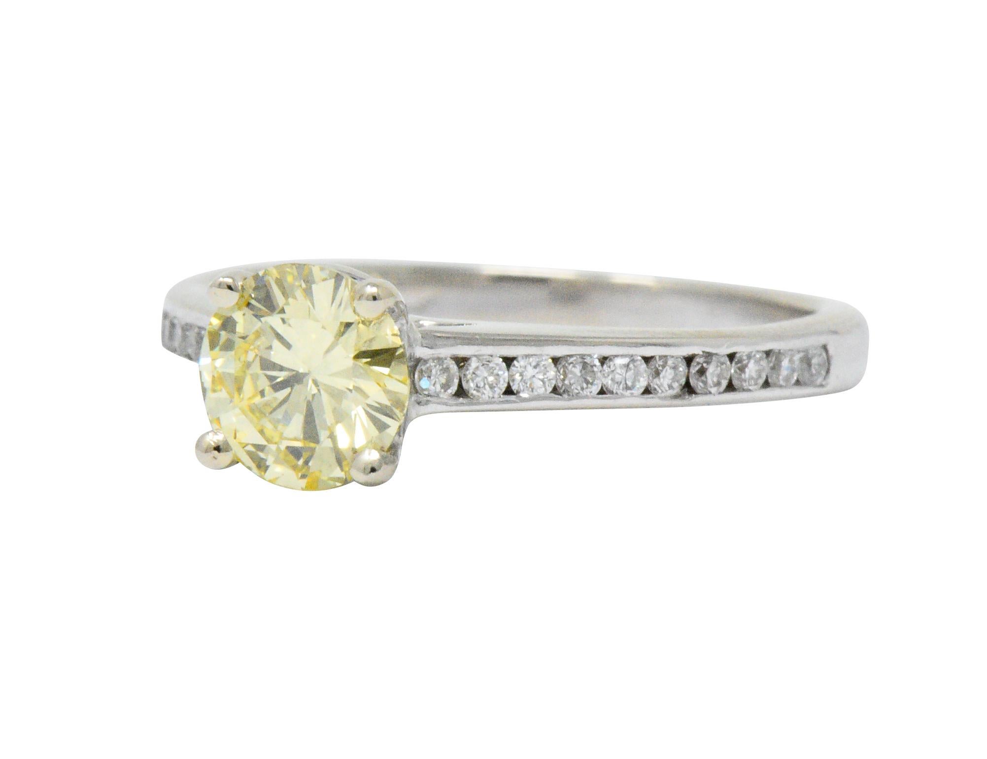 Centering a round brilliant cut diamond weighing 0.64 carat, natural fancy yellow in color with SI1 clarity

Flanked by channel set round brilliant cut diamonds weighing approximately 0.15 carat total, G/H color with SI clarity

Tested as 14 karat