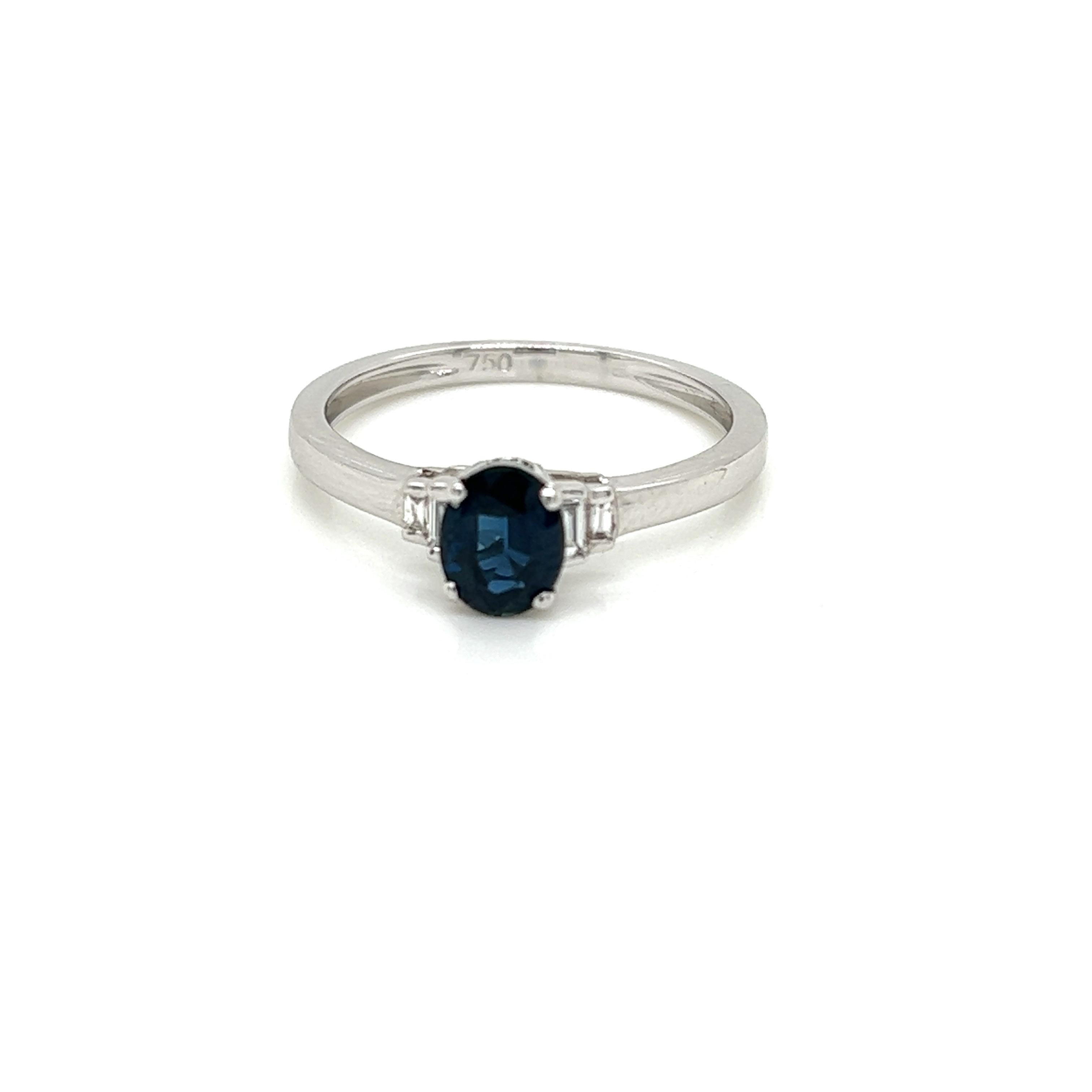 This timeless ring features a resplendent 0.79 carat oval Blue Sapphire held in a claw setting at its centre. On either side of it are two baguette cut Diamonds, weighing 0.07 carats in total and set in 18K White Gold.

This alluring ring is