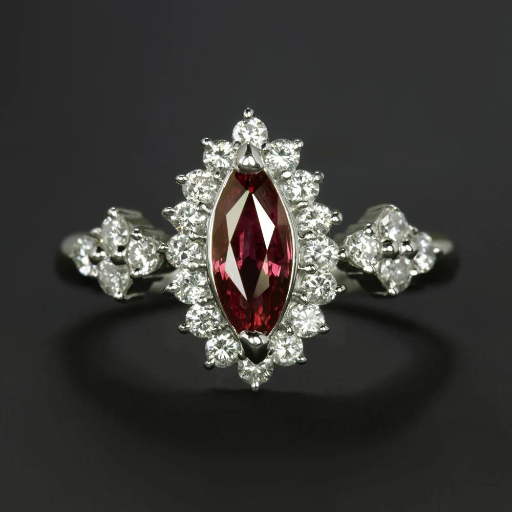 This exquisite ruby and diamond ring features a rich red marquise ruby surrounded by a vibrant diamond halo and accented by bright diamond clusters.
Crafted in high-quality platinum and weighing 7.0 grams, this stunning ring showcases a total carat