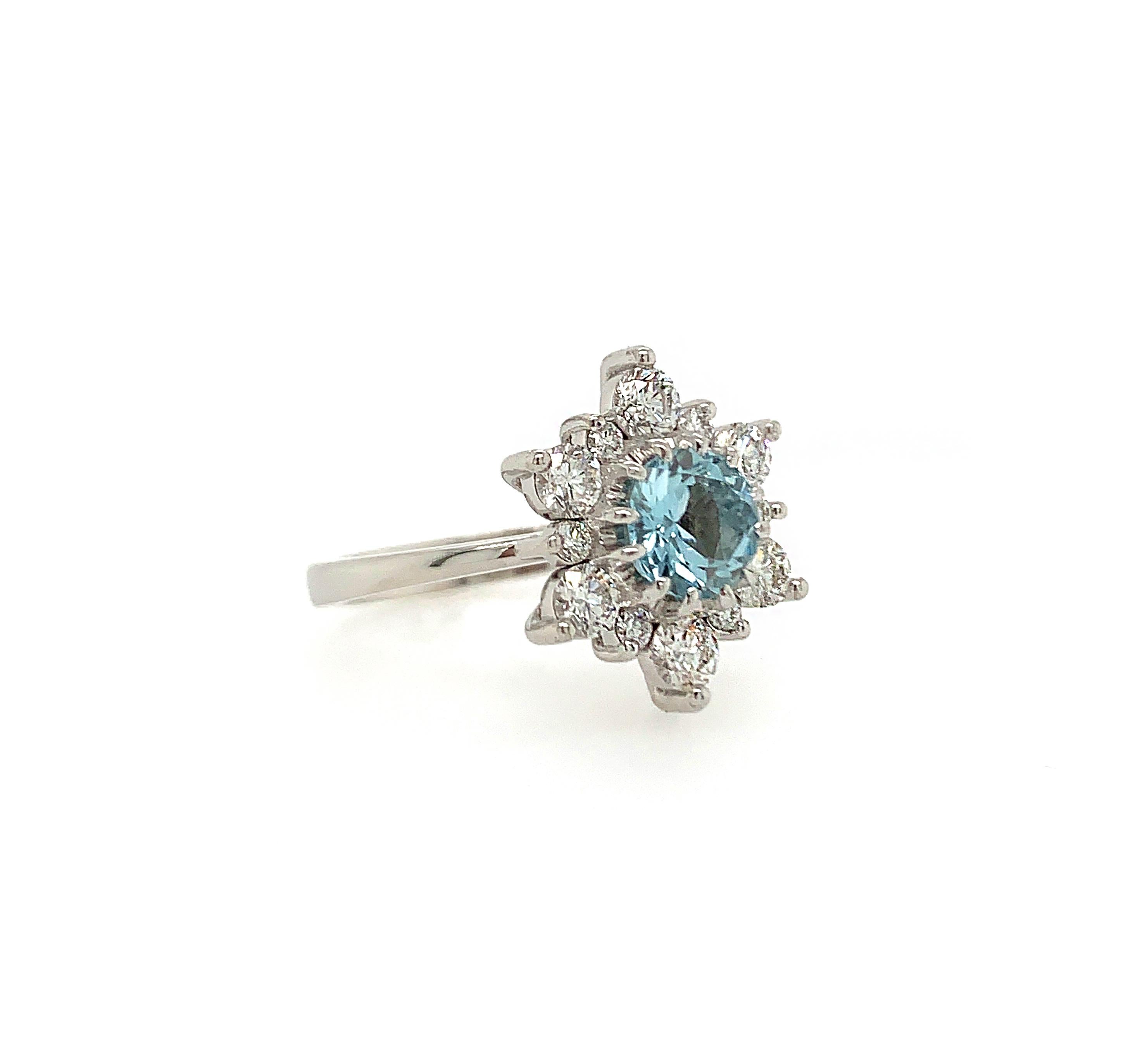 This beautiful ring features a 0.80 carat round natural Aquamarine set atop an array of 12 white round brilliant diamonds in a snowflake pattern. 

Set in 14K white gold. 

Center stone: Natural Aquamarine - 0.80 carat.

Accent stones: Natural white