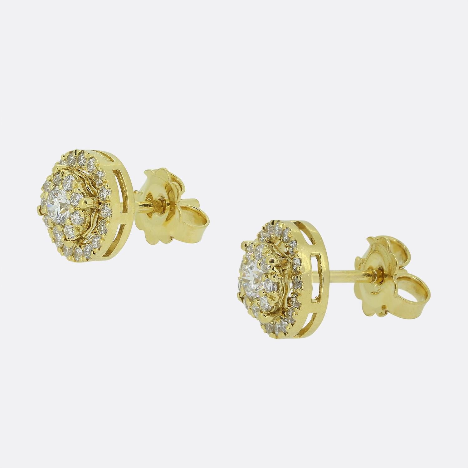 Here we have a stunning pair of 18ct yellow gold diamond cluster earrings. Each identical piece takes on a rounded shape and features a single 0.14 carat round brilliant cut diamond at the centre surrounded by a double halo of smaller matching