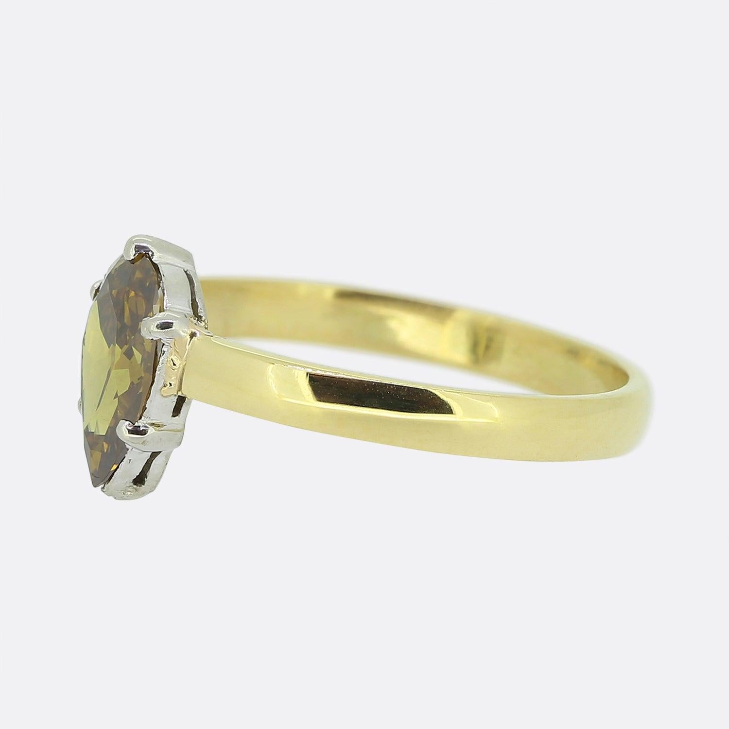 Hier haben wir einen klassisch gestalteten diamantenen Solitär-Verlobungsring. Dieses Vintage-Stück zeigt einen einzelnen birnenförmigen Diamanten mit einem ausgefallenen goldbraunen Farbton in einer Platinfassung mit fünf Krallen. Dieser