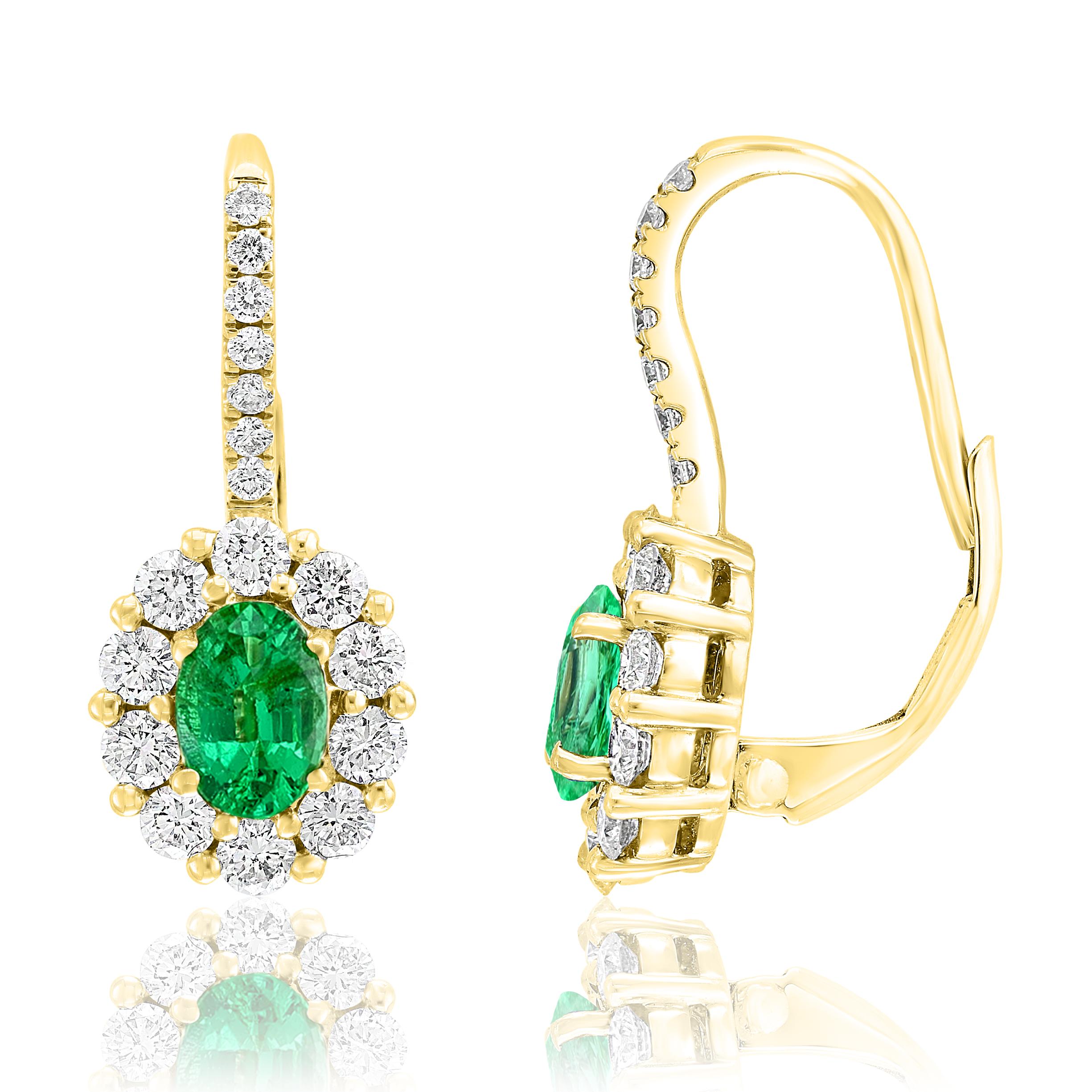 A simple pair of Lever back earrings showcasing 0.80 carats of oval cut green Emeralds, surrounded by a single row of 34 round brilliant diamonds weighing 0.92 carats. Made in 18-karat Yellow gold.