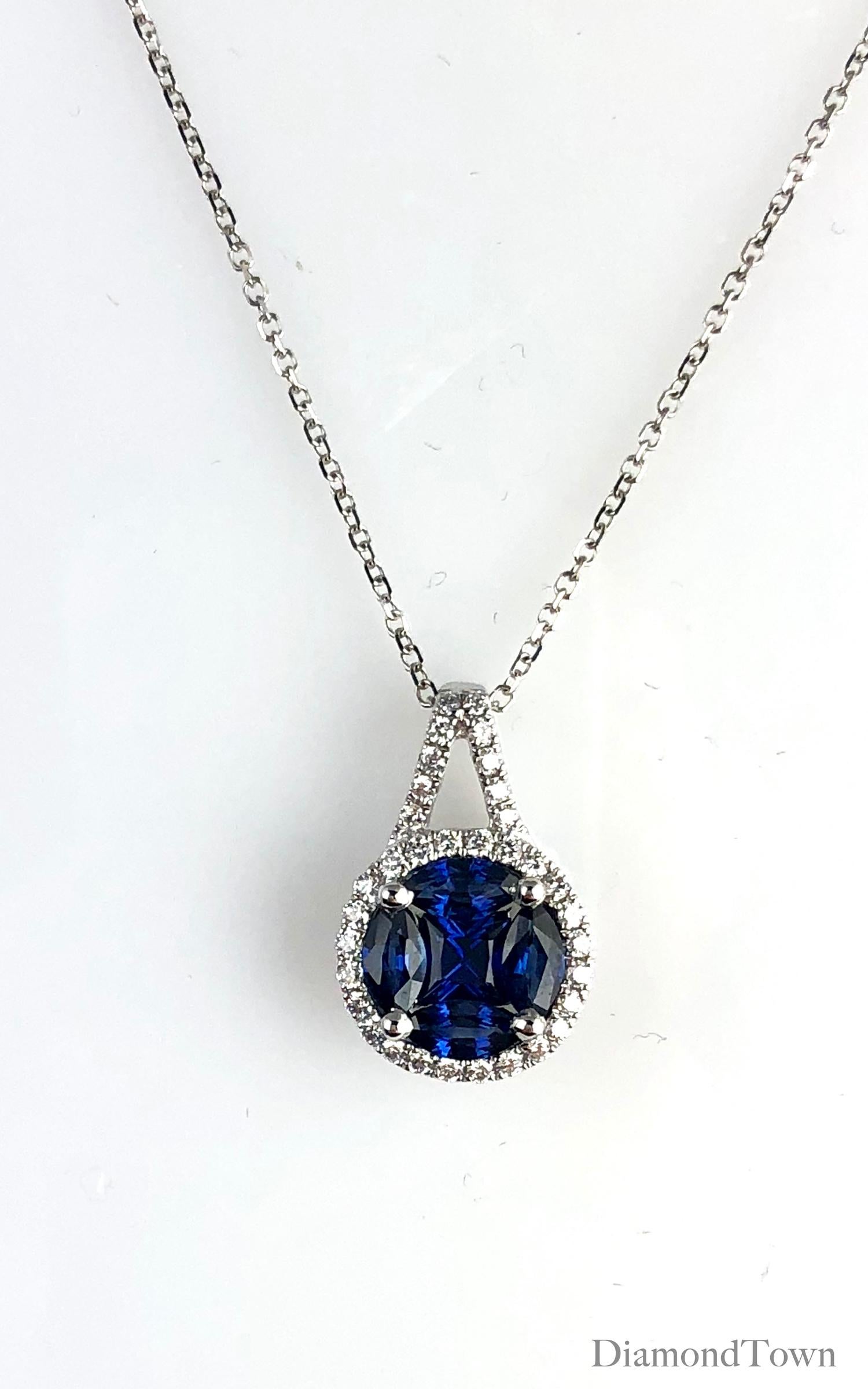 This pendant features a vivid blue sapphire cluster center (5 stones, total weight 0.80 carats) surrounded by a halo of round white diamonds, which also extend up the bail. Total diamond weight 0.19 carats.

Set in 18k White Gold

Matching earrings