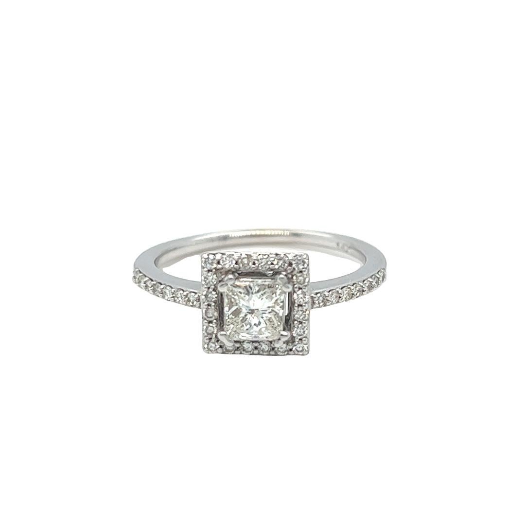 Estate 14k white gold diamond engagement ring features a princess cut diamond weighing approximately .55 carat with H color and SI clarity. The shimmering bead set halo around the solitaire is comprised of 20 round brilliant cut diamonds. More