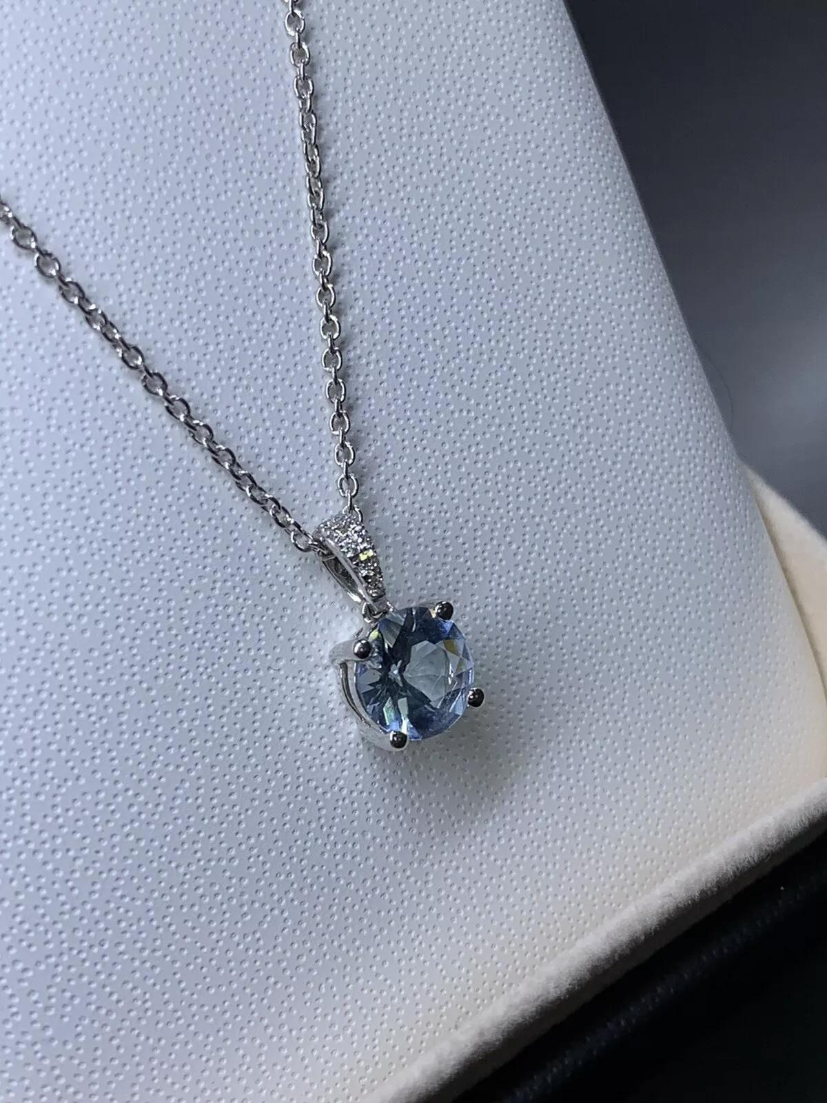 0.80ct Aquamarine and diamond halo pendant necklace in 18k white gold.

Aquamarine natural light blue colour 0.80ct.

Hallmarked.

Diamonds hidden halo 0.10ct F colour VS1 clarity

Box and valuation included.
Elevate your jewellery collection with