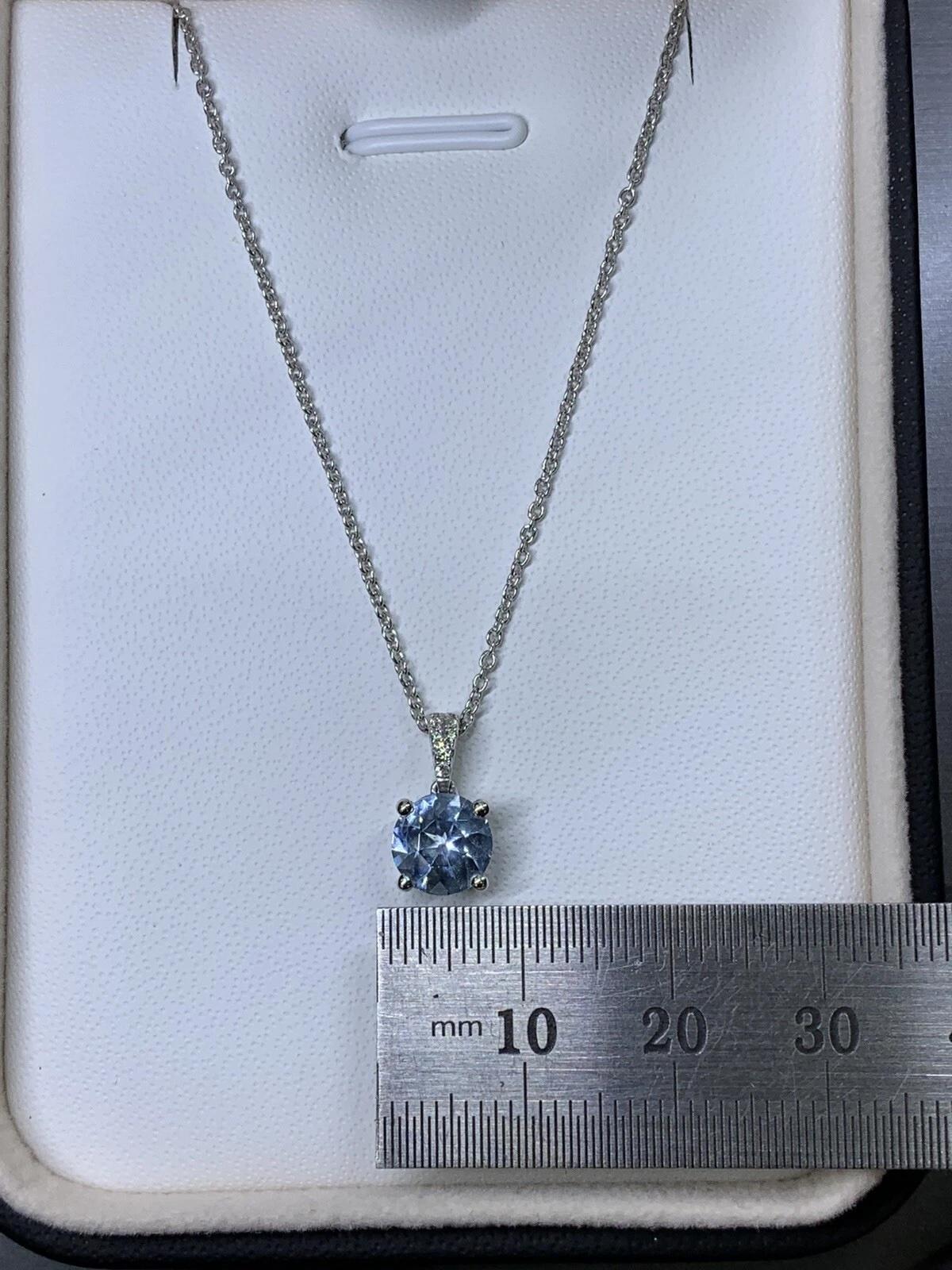 Round Cut 0.80ct Aquamarine and diamond halo pendant necklace in 18k white gold. For Sale