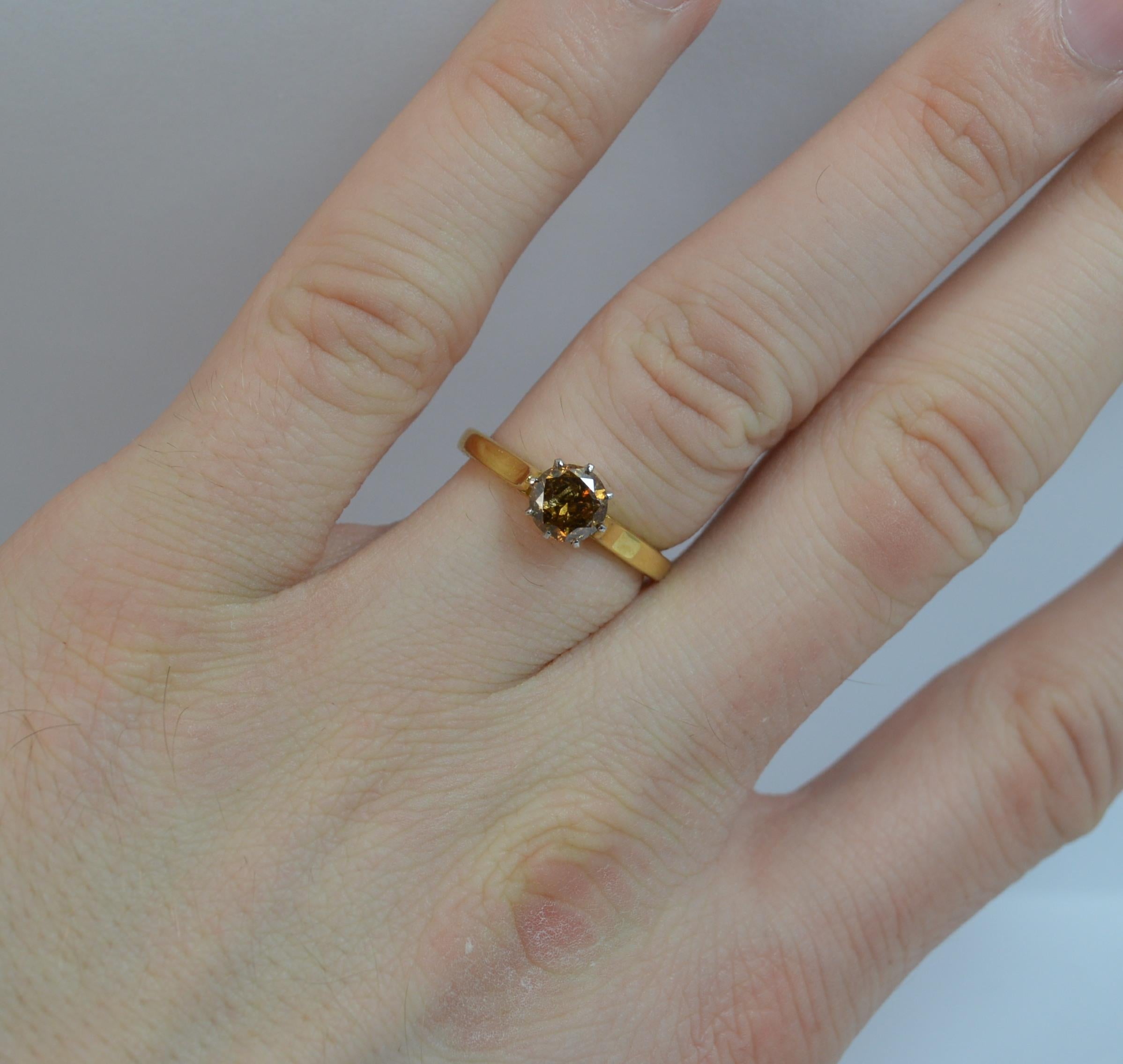 A large and natural Diamond and 18ct Gold ring.
SIZE ; L 1/2 UK, 6 US
​Set with a round brilliant cut diamond to measure 5.8mm in diameter in an eight claw setting. 0.80 carats.

All modelled in a 18 carat yellow gold shank and platinum