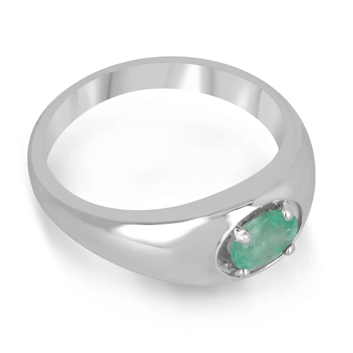 A dapper natural emerald oval cut solitaire ring. This exquisite piece features a gorgeous oval-cut emerald from the mines of Zambia. The gemstone showcases a beautiful shine, mossy medium green color, and good luster. Four-prong set in a shiny