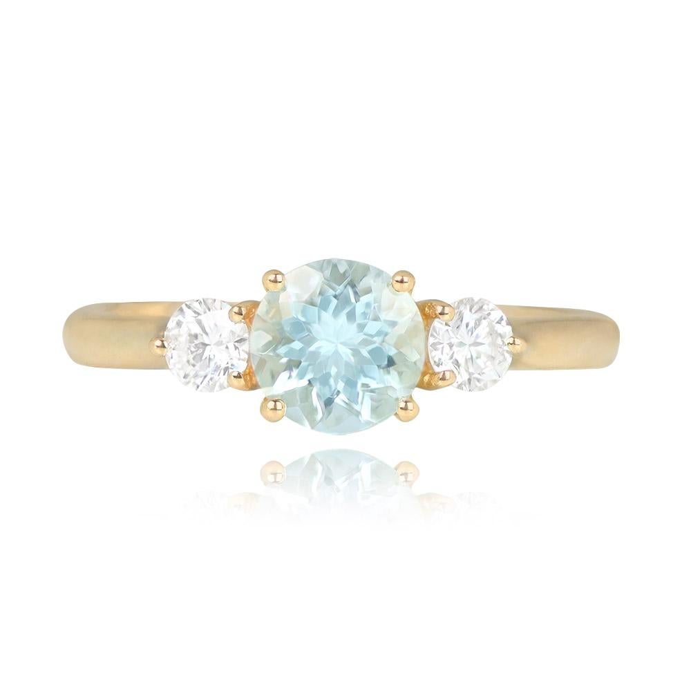 An 18k yellow gold ring with a round 0.80-carat aquamarine center stone, secured with prongs. It boasts additional elegance with a round brilliant cut diamond on each shoulder, totaling about 0.25 carats of diamonds.


Ring Size: 6.75 US,