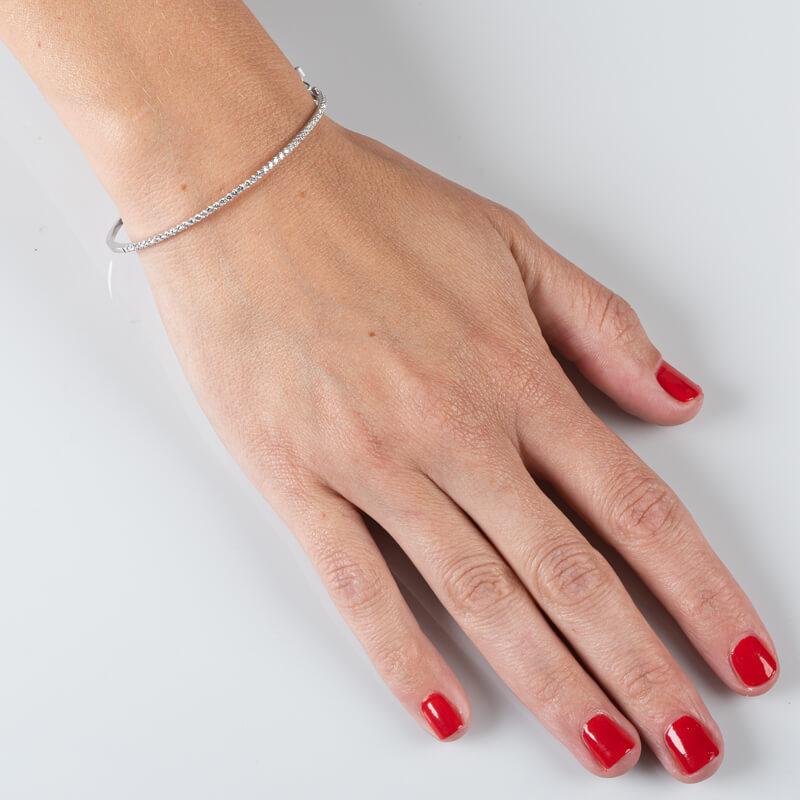 This bangle bracelet features 0.80ct total weight of 45 round brilliant cut diamonds set with split prongs that go halfway around the bangle. It is set in 18 karat white gold with a double safety catch box clasp. 
Measurements: This will fit up to a