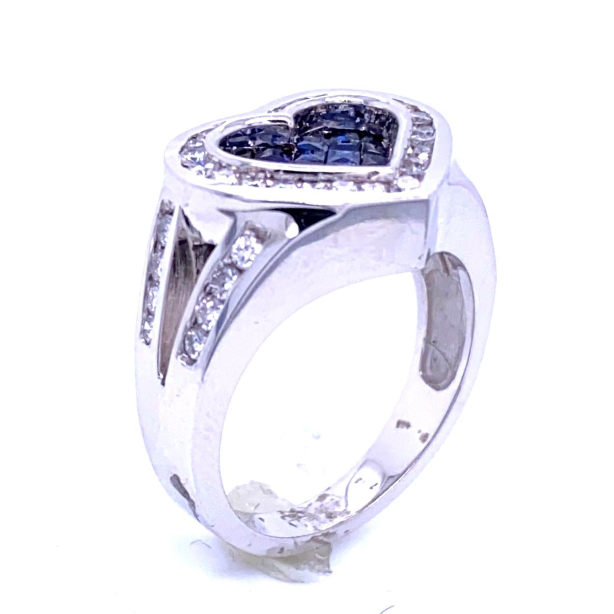 Anello con gambo diviso a forma di cuore in oro 18K con 21 zaffiri blu taglio principessa incastonati (peso totale delle gemme 0,92 carati) circondati da un'aureola di diamanti incastonati a canale e gambo diviso a canale con peso totale di 0,81