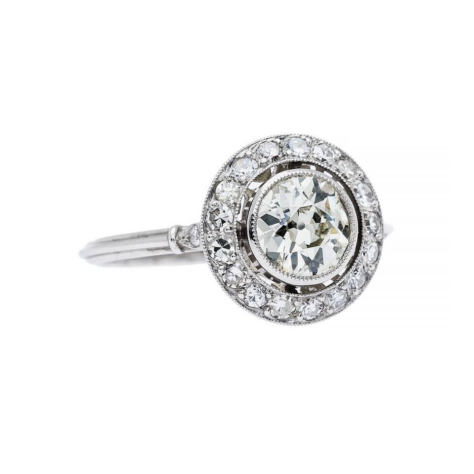 Inspiration derived from the greatest era of jewelry, Art Deco,  features the iconic design that seems to never go out of style. Forming the iconic halo engagement ring is a 0.82 carat old European cut diamond that is K-L color, SI1 clarity.