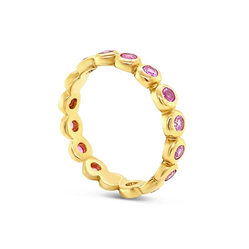 This versatile and beautiful eternity band features 0.83 carat total weight in round pink sapphires that are bezel set in 14 karat yellow gold. This ring is a size 7.
