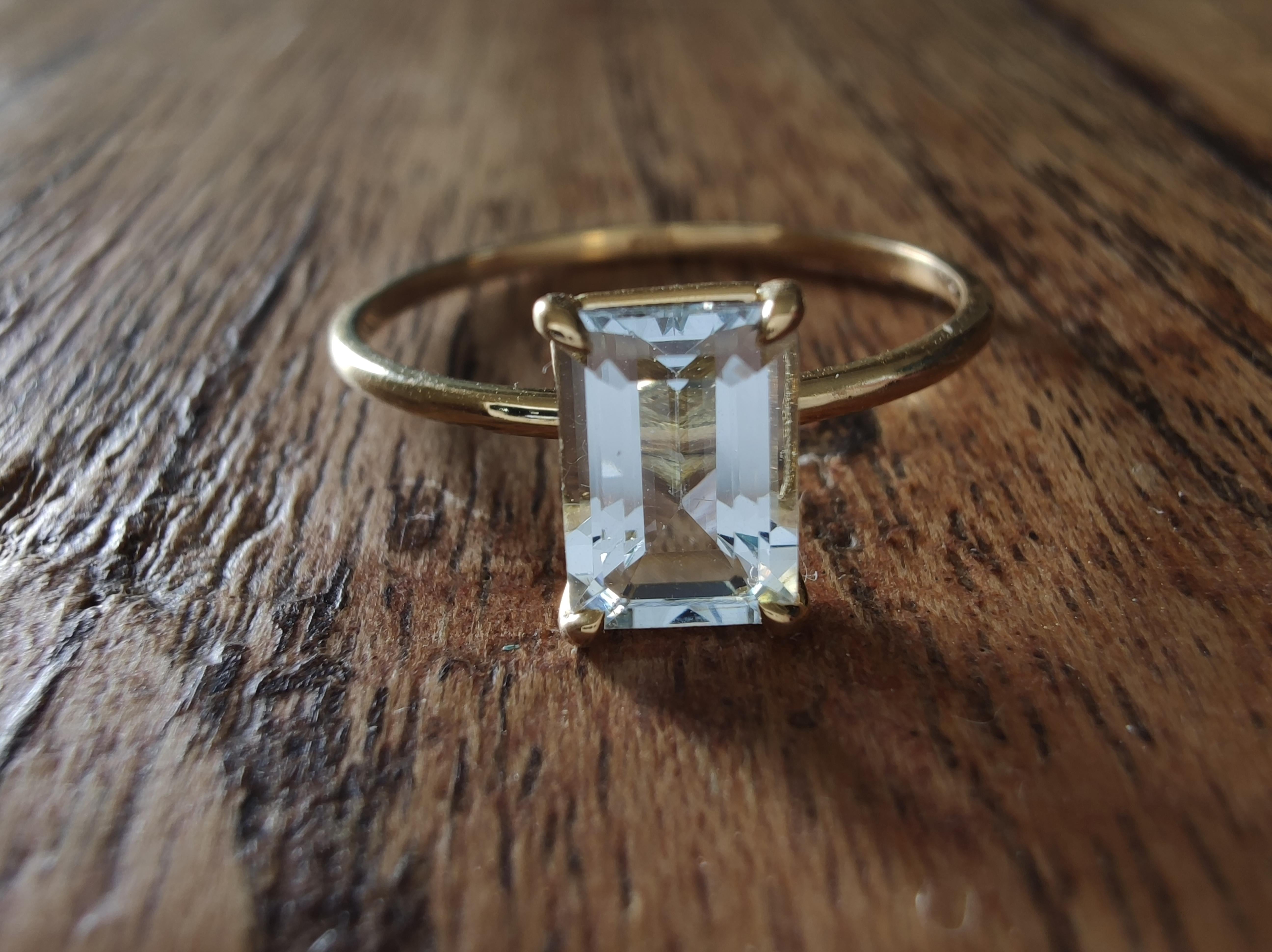 Sleek, refined, and modern—this aquamarine solitaire ring is a tribute to minimalist beauty. Handcrafted in solid 18K yellow gold, the design showcases a natural 0.83-carat emerald-cut aquamarine, admired for its serene light blue hue and high