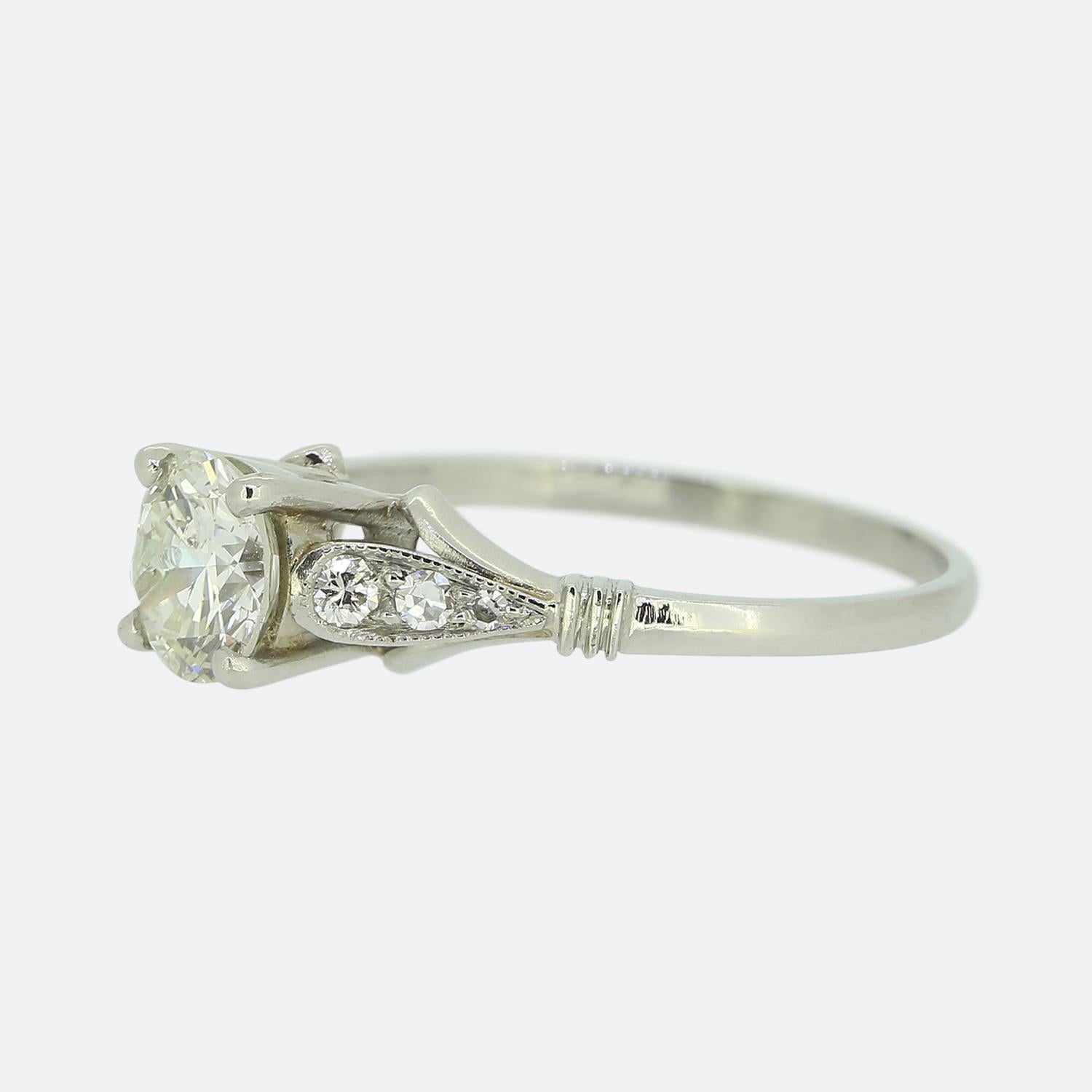 Hier haben wir einen entzückenden Verlobungsring aus Platin mit Diamanten. Im Mittelpunkt dieses Rings steht ein runder Diamant im Brillantschliff von 0,84 Karat, der allein und stolz in der Mitte der Vorderseite in einer Fassung mit vier Krallen