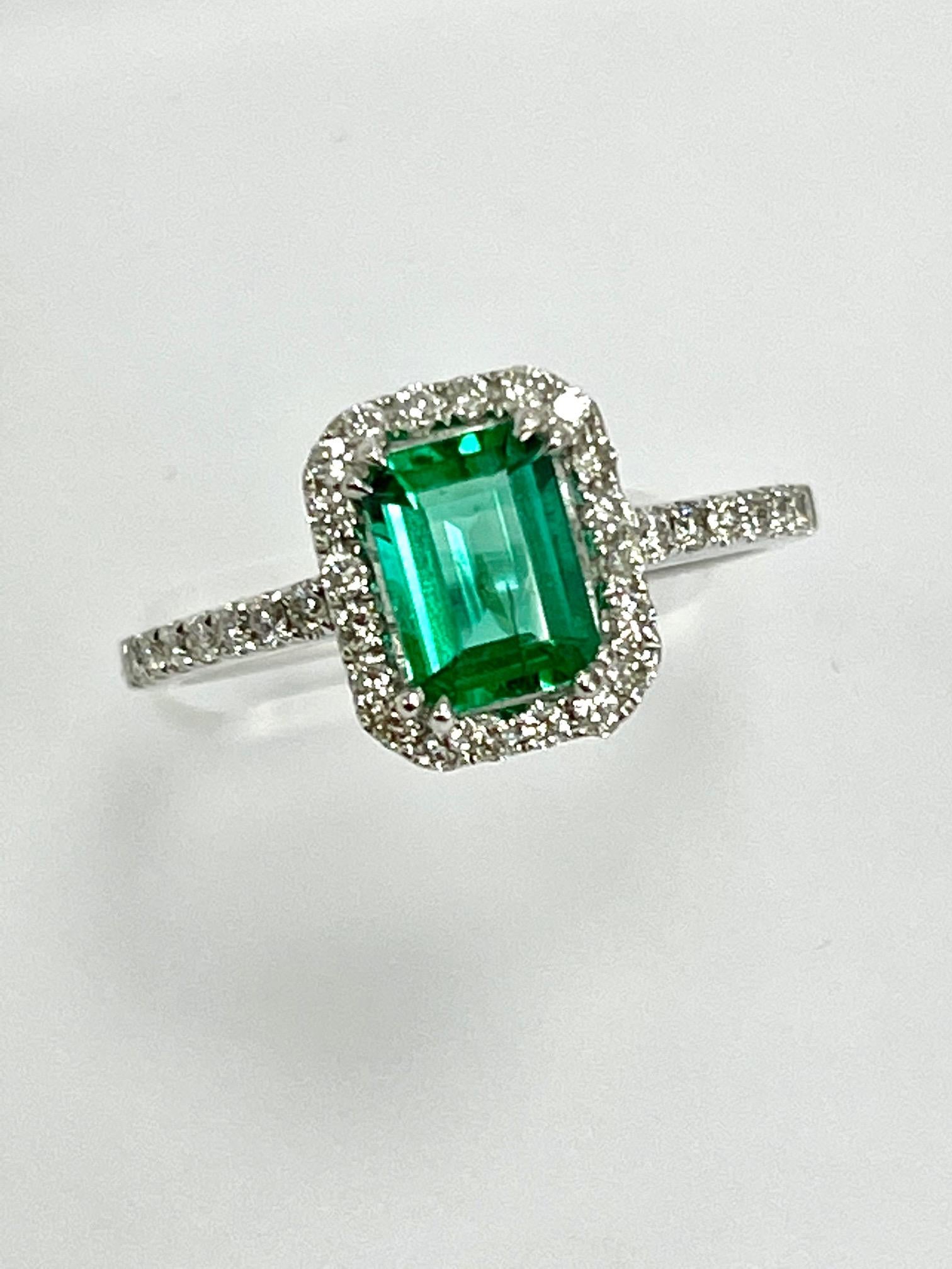 0.84 Carat Zambian emerald cut emerald set in 18k white gold ring with 0.36 carat diamonds .
