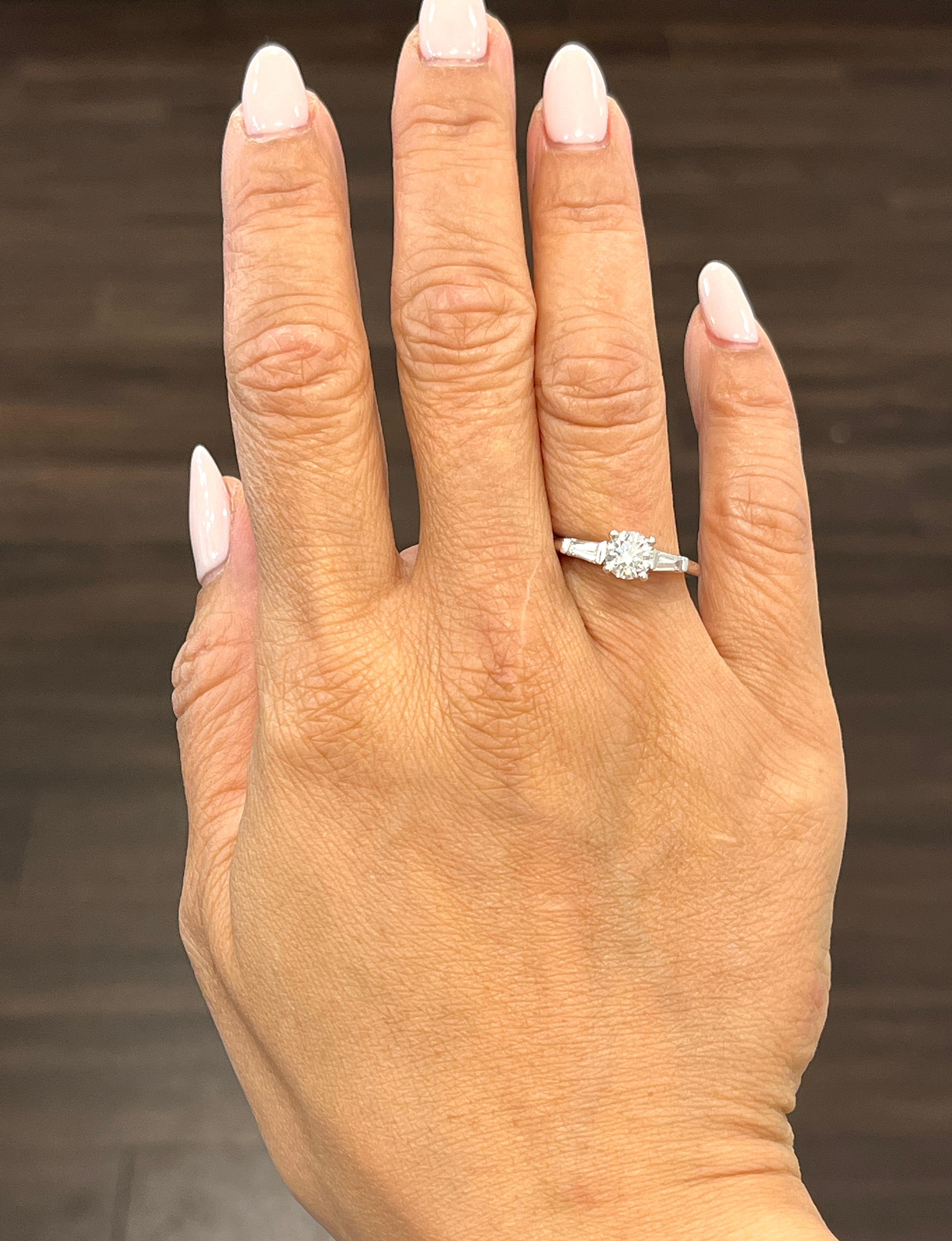 Este precioso anillo tiene un diamante redondo central y 2 diamantes trapezoidales de 0,84 quilates engastados en platino. La piedra central tiene un color F/G y una claridad SI2/I1. Las piedras laterales son de color F/G y claridad VS1/VS2. ¡Un
