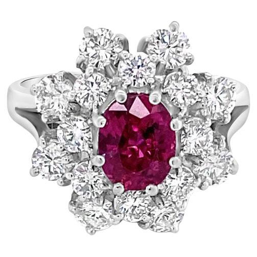0.85 Carat Oval Cut Ruby surrounded by 2.50ctw Diamonds, 18 Karat White Gold For Sale