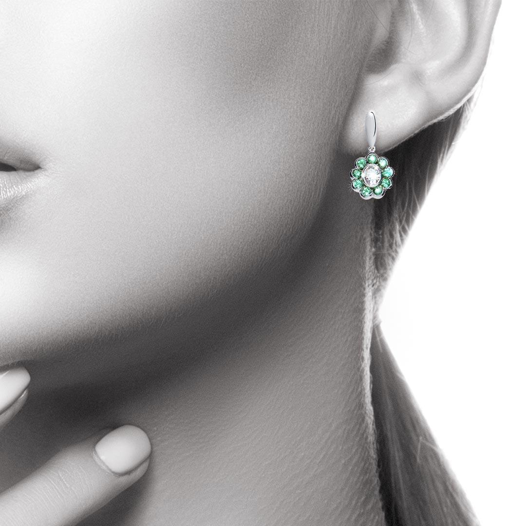 A gorgeous pair of oval diamonds are offset by a flower-shaped cluster of lively round mint green tourmalines. A striking pair of earrings which can be worn for work and pleasure. Total weight for the 2 Oval Diamonds is 0.85 carat, Colour F/G,