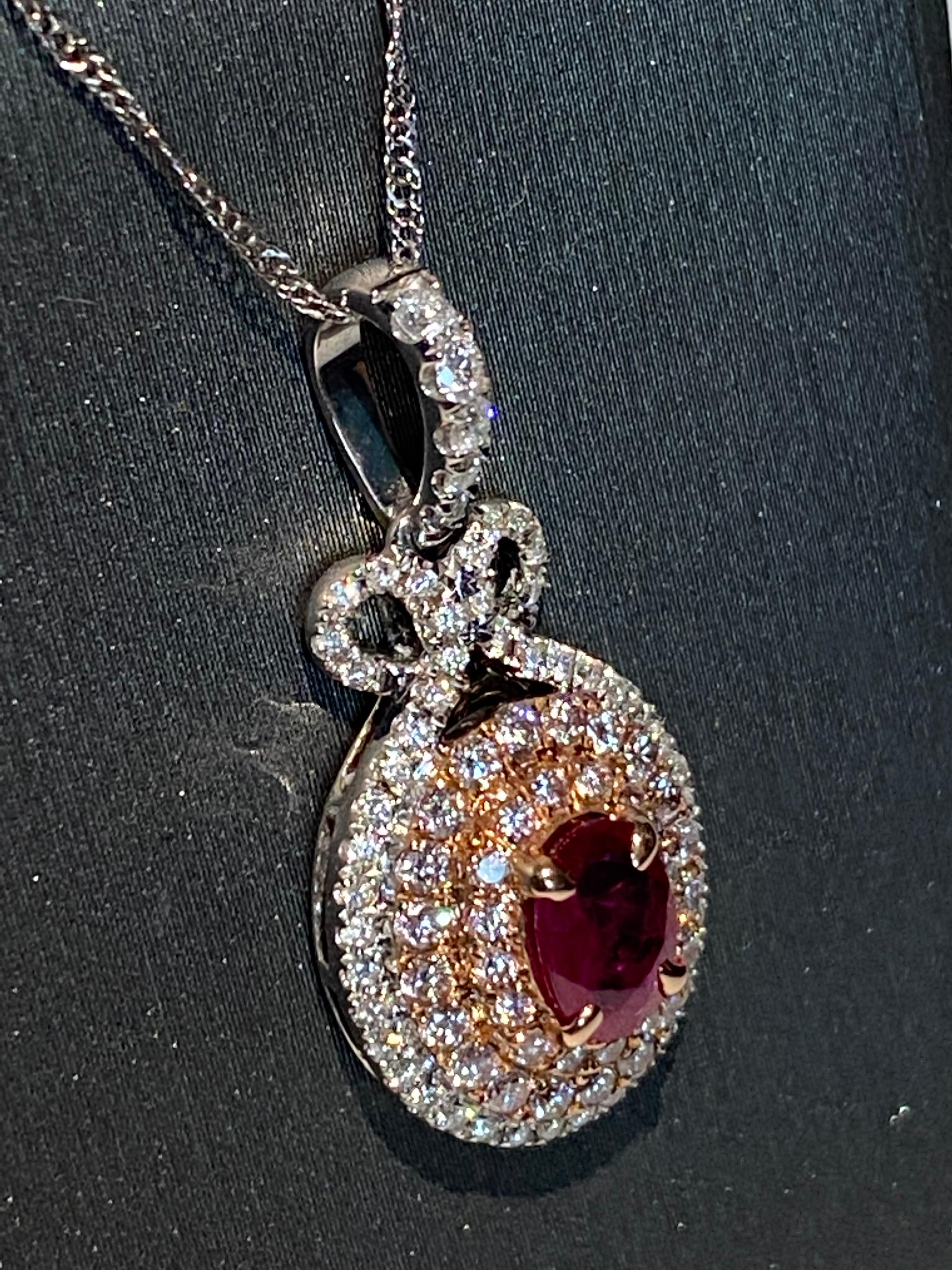 Oval ruby is framed by three rows of pink and white diamond. it is set in two tone gold and crafted with hand.
White gold chain is included with the pendant. 
Ruby: 0.85ct
Pink Diamond: 0.43ct
White Diamond: 0.32ct
Two Tone Gold: 14K
Length: 18 inch