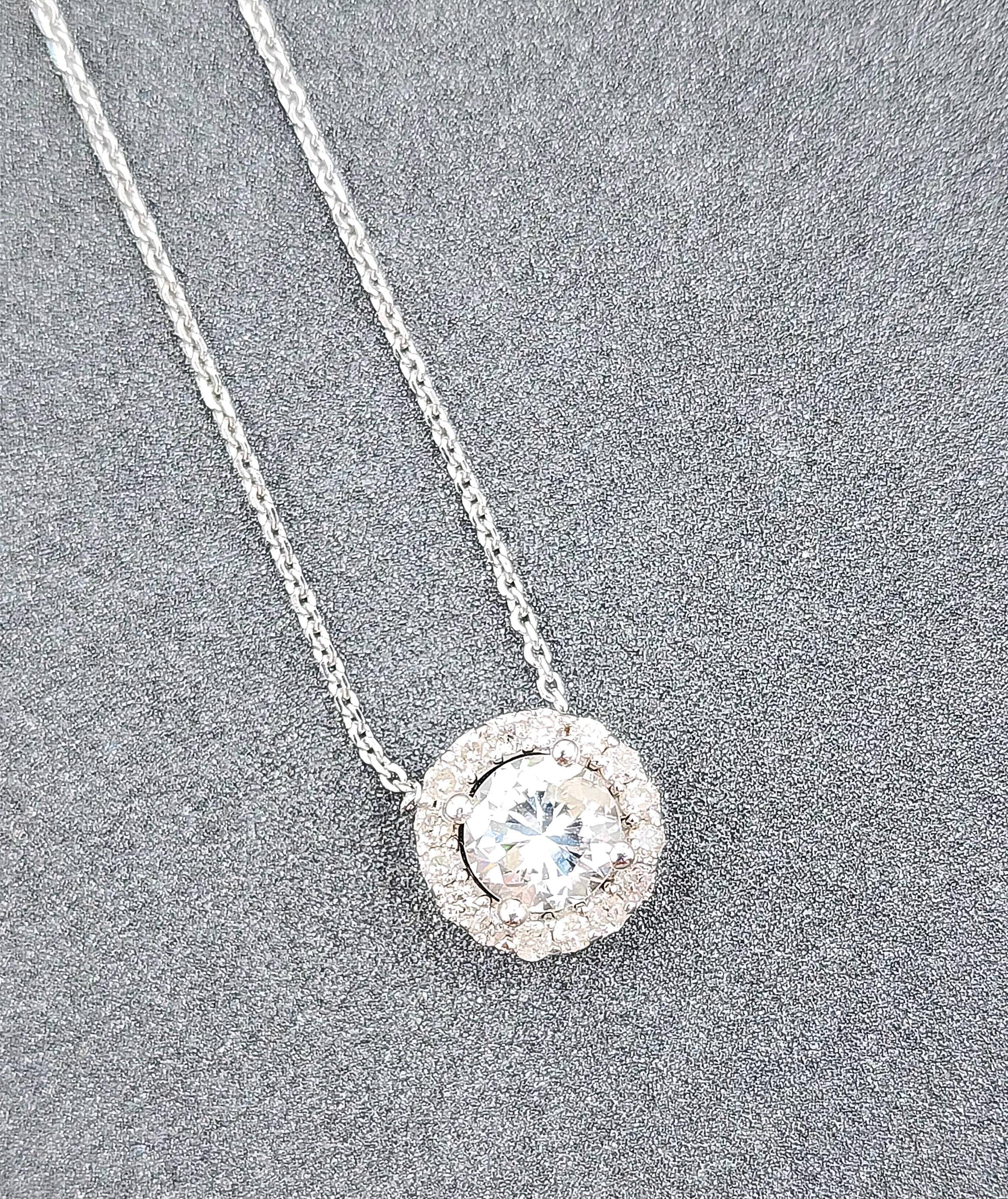 Ce collier à pendentifs exquis est un magnifique exemple de savoir-faire artisanal. Il comporte un diamant rond de 0,65 ct de pureté I1/I2 et de couleur G/H, entouré de diamants ronds secondaires de 0,20 ct de pureté I1/I2 et de couleur G/H. Les