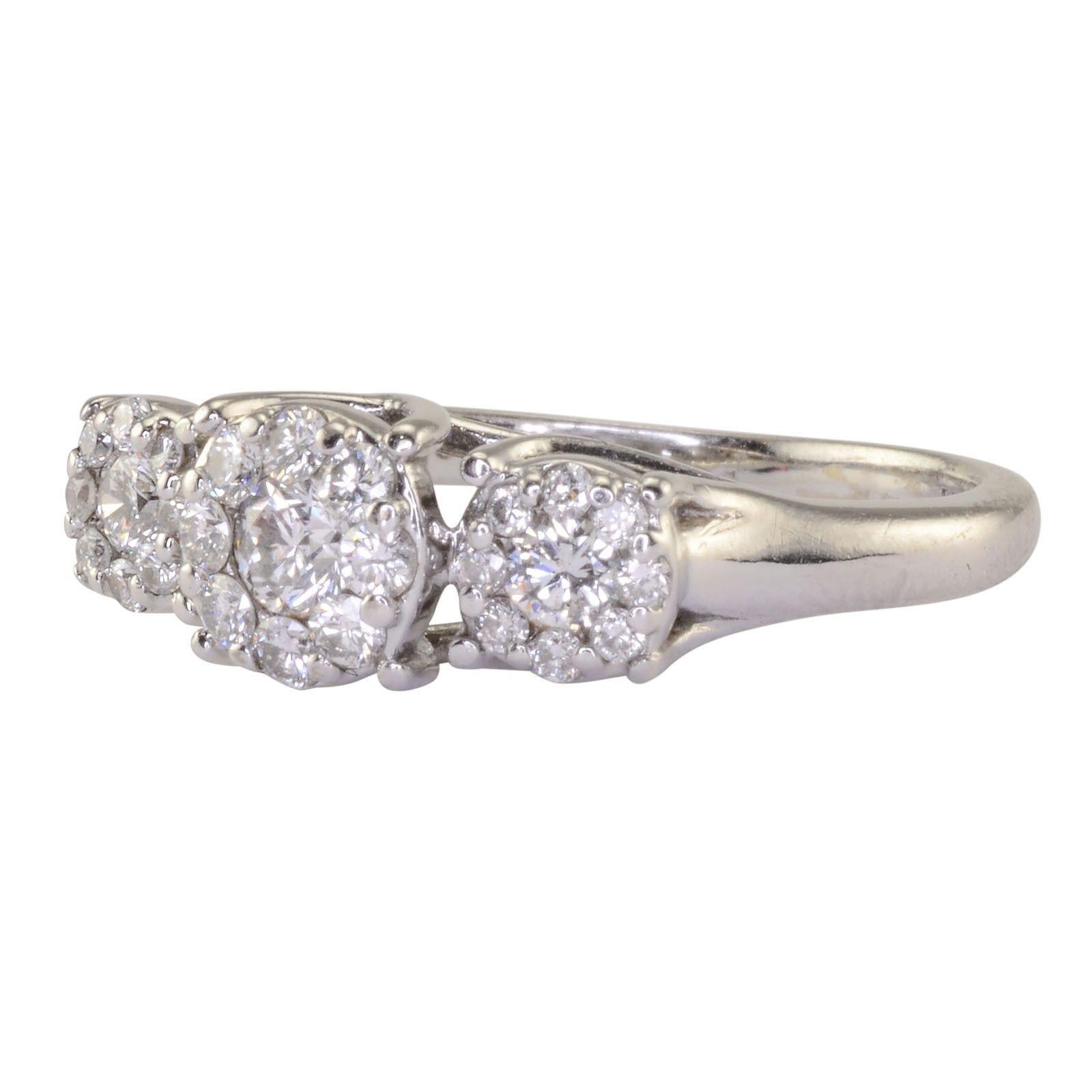 Estate 0.85 CTW diamond 18K white gold ring. This diamond engagement ring has three round brilliant diamonds and small surrounding diamonds at 0.85 carat total weight SI clarity G color. The 18 karat white gold diamond ring is a size 5. [KIMH