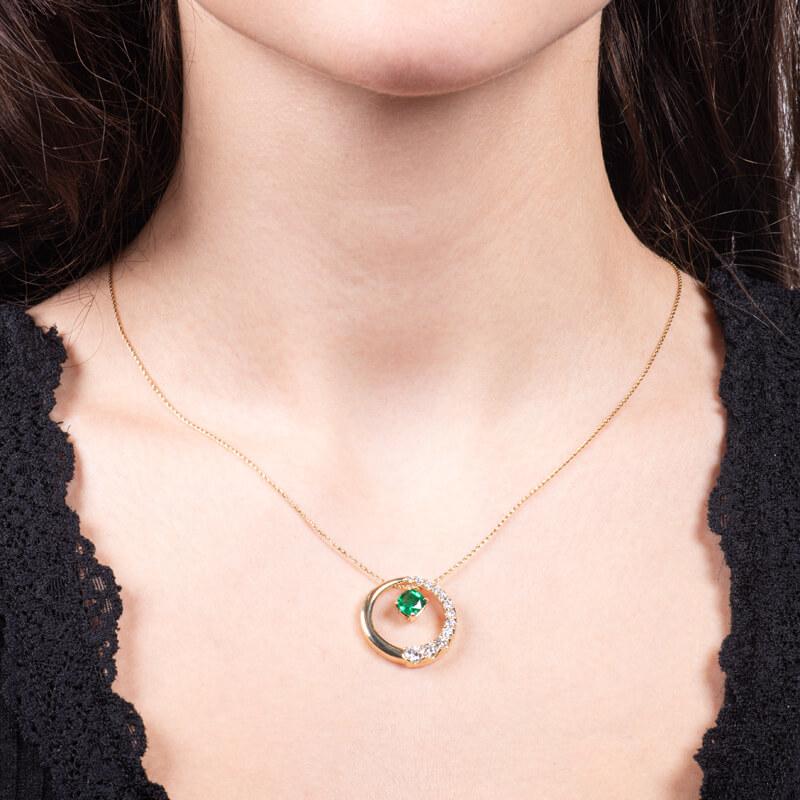 This incredible necklace features a stunning 0.85ct, GIA certified (#2215623972), cushion cut natural emerald, surrounded by 0.50ct total weight in round diamonds forming a crescent shape around the 14kt yellow gold hoop around the emerald. The