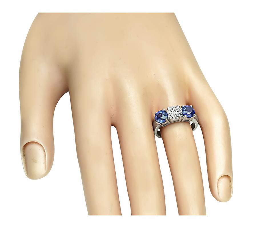 Voici une fabuleuse bague à trois pierres en or blanc 14k. La bague est sertie d'un diamant rond étincelant et de deux saphirs ronds qui pèsent respectivement environ 0,85ct et 2,50ct. La couleur du diamant est G avec une clarté VS. La partie