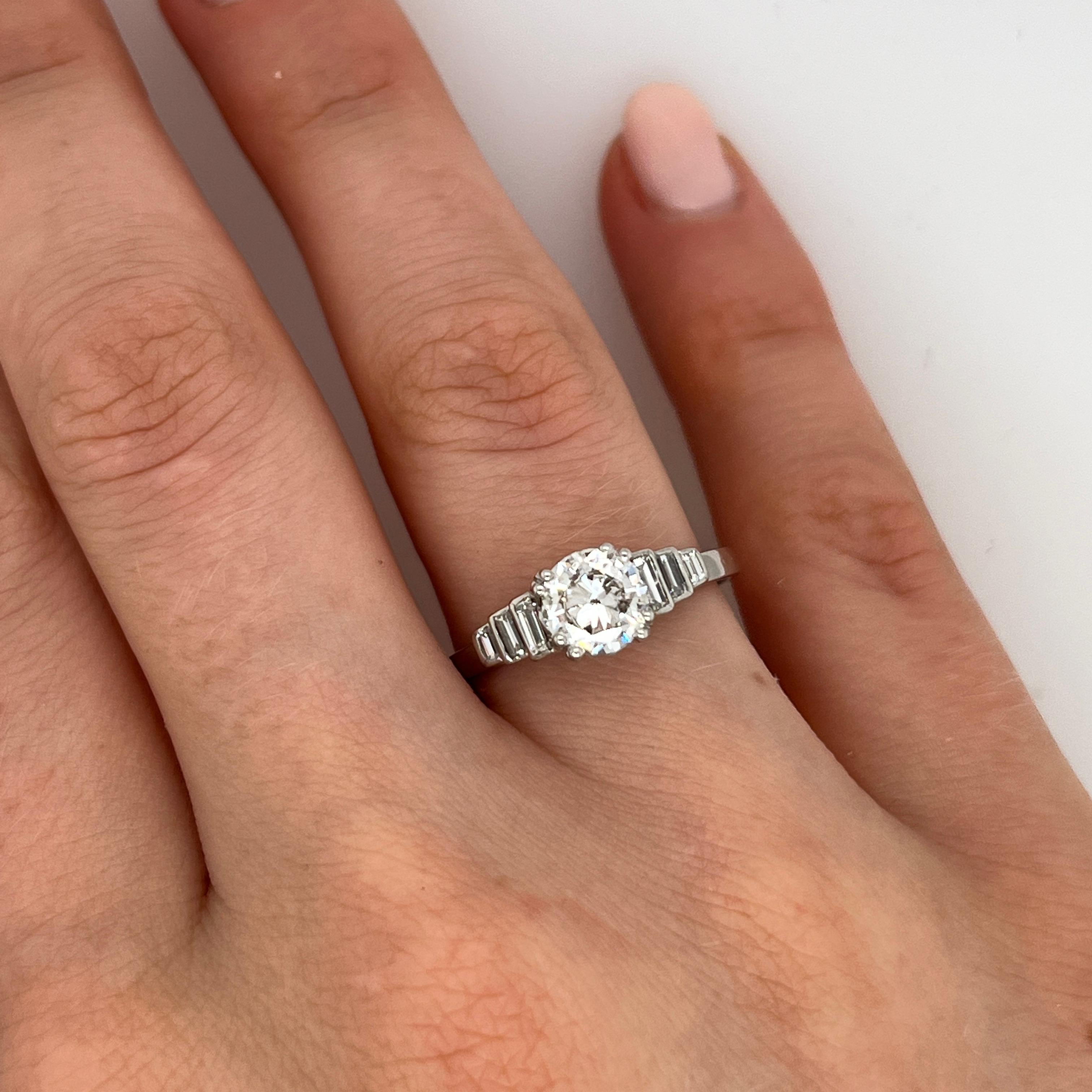 A stunning 0.85ct round brilliant cut diamond ring, set in timeless platinum. The diamond is graded J colour, SI3 clarity, offering beautiful sparkle flanked by three baguette diamonds on each shoulder for added brilliance and vintage charm.

Total
