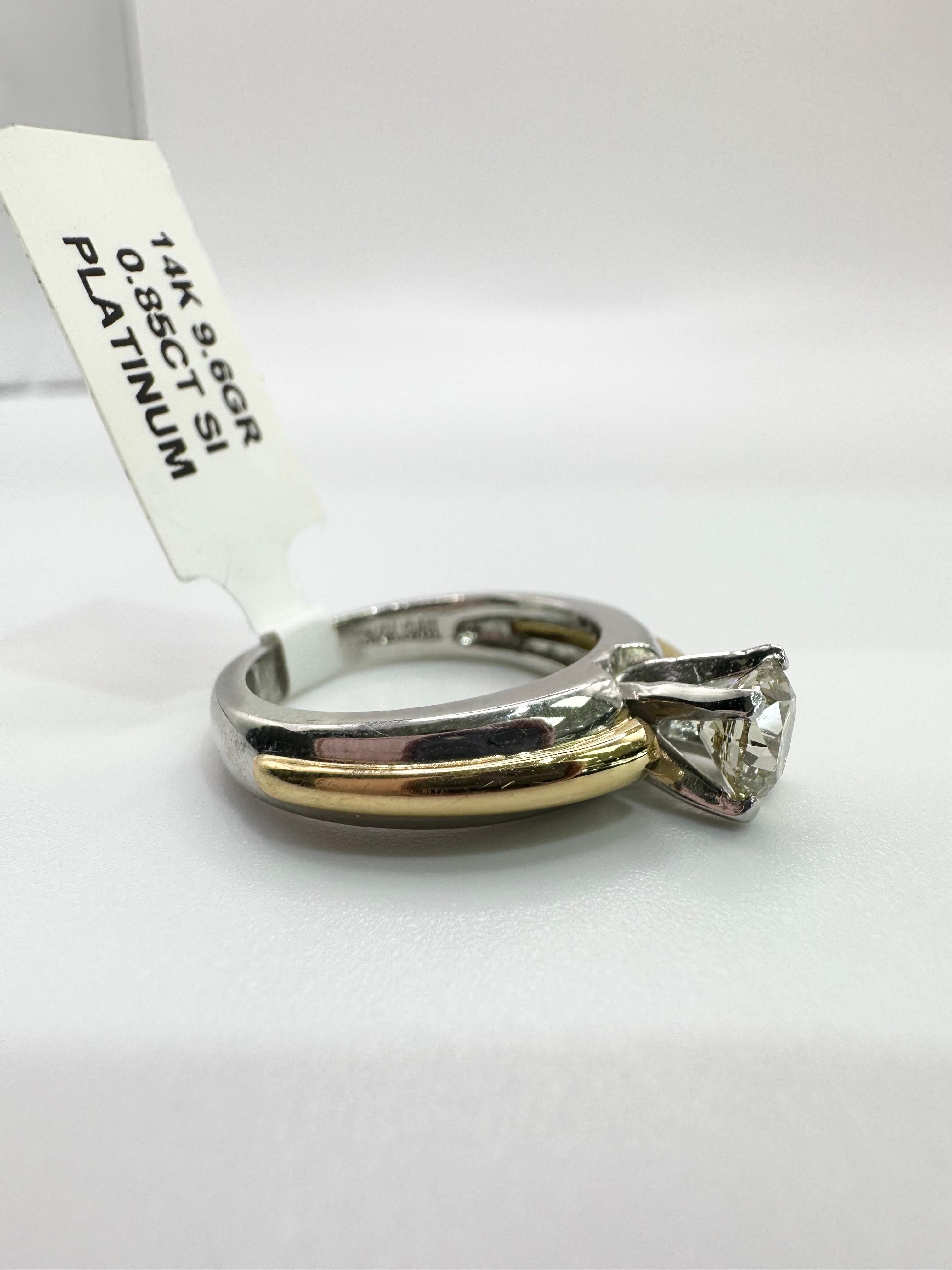 Vintage style platinum diamond enagement ring made with platinum and 14KT yellow gold rim. The ring is made with 0.85ct ct Si2/I color diamond in center and is currently a size 7. Ring can be re-sized. Handling time to ship out is 10 days.