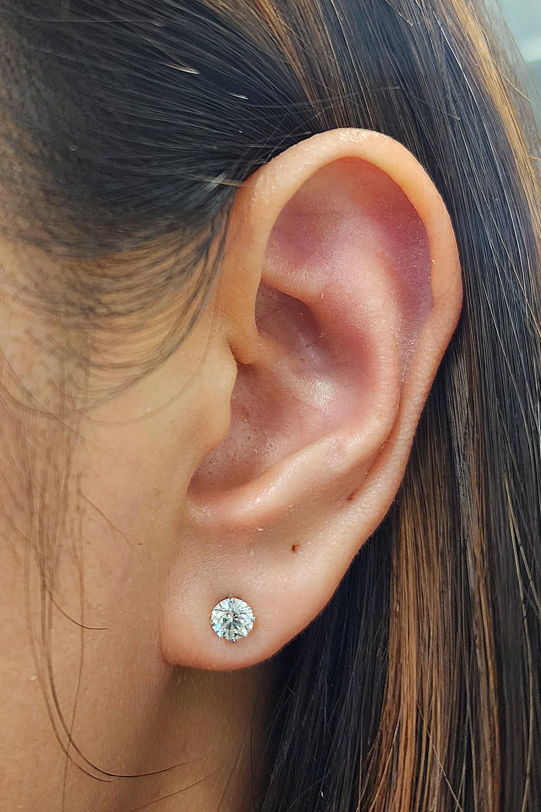 Ces boucles d'oreilles exquises sont composées de 0,86 carats de diamants blancs de taille ronde sertis dans de l'or blanc 14 carats. Les diamants sont classés G/H pour la couleur et SI1/SI2 pour la pureté. Fabriquées dans un style moderne aux