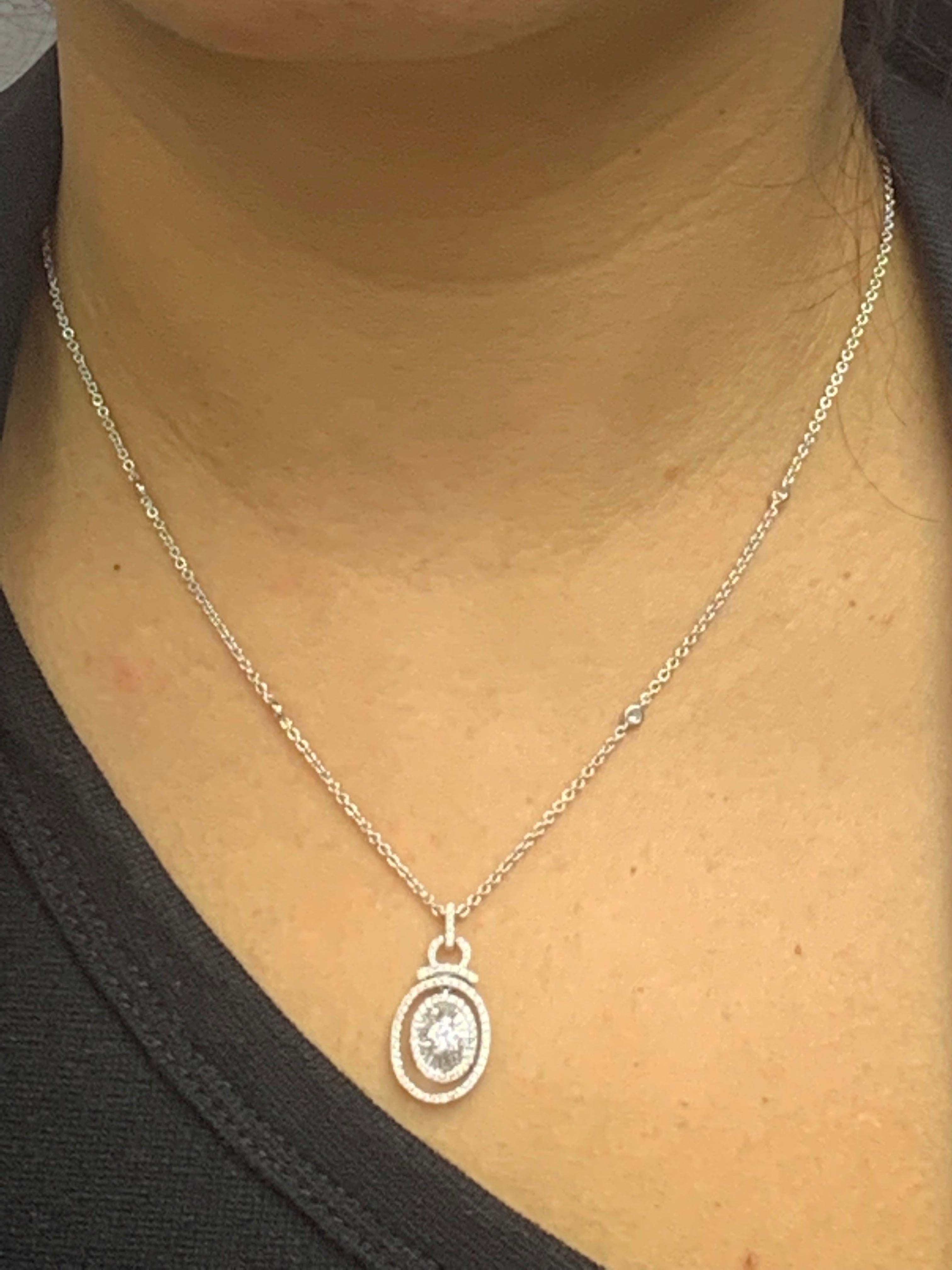 A simple and classic pendant necklace showcasing mixed cut diamonds, 86 round diamonds weigh 0.45 carat, 19 baguette diamonds weigh 0.25 carat and 1 brilliant cut diamond in the center weighs 0.17 carat in total. they are set in an open work design.