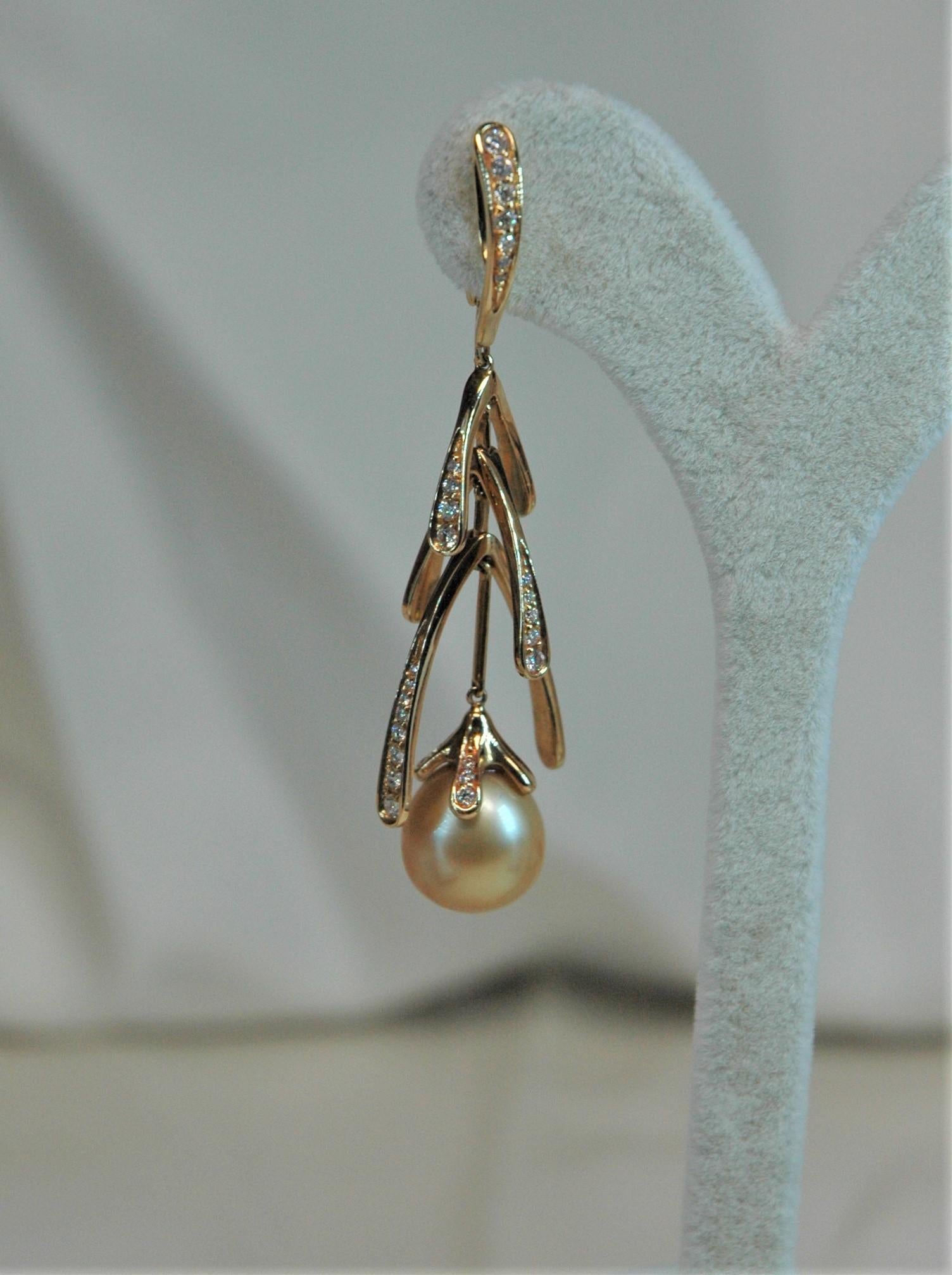 Ces merveilleuses boucles d'oreilles sont réalisées en or jaune avec des diamants et des perles dorées. Ils sont complètement mobiles dans leur longueur, ce qui leur donne une légèreté de mouvement appréciable. Il existe également la bague parfaite
