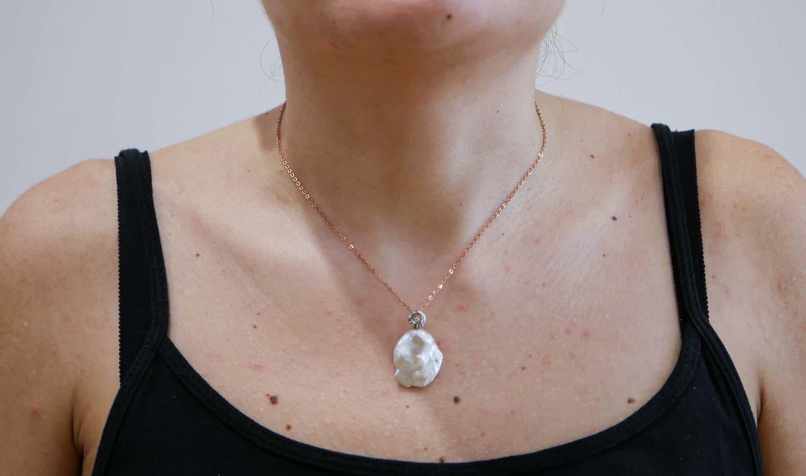 Collana con ciondolo Retrò in oro rosa 9 kt e struttura in argento montata con un diamante vecchio taglio e, sotto, una perla barocca. La catena d'argento è inclusa.
Questo ciondolo è stato realizzato completamente a mano da maestri orafi italiani