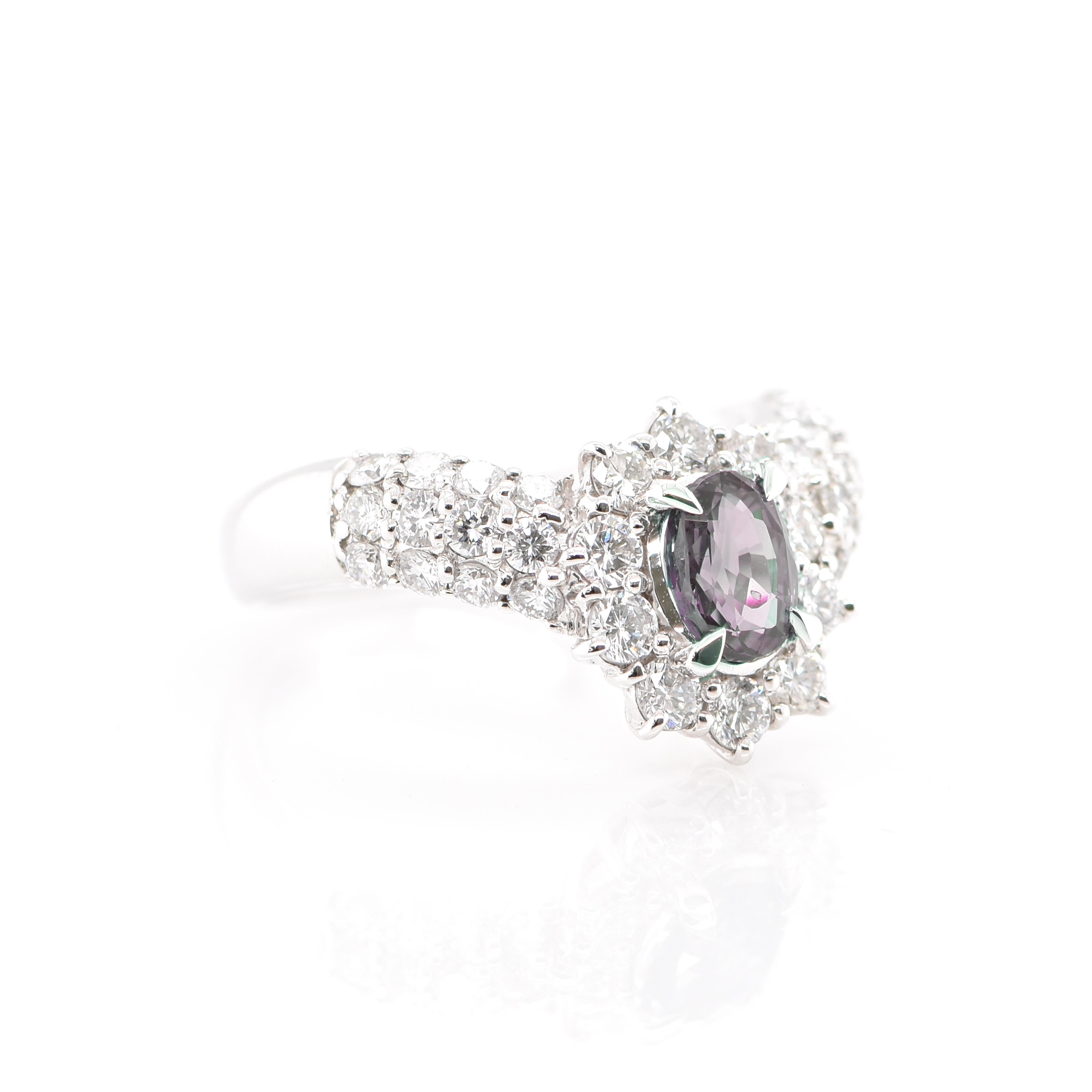 A gorgeous Cluster Ring featuring a 0.88 Carat Alexandrite and 1.14 Carats of Diamond Accents set in Platinum. Alexandrites produce a natural color-change phenomenon as they exhibit a Bluish Green Color under Fluorescent Light whereas a Purplish Red