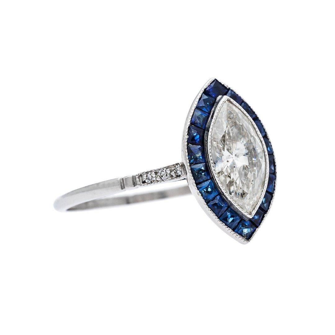  Featuring a 0.88 carat marquise cut diamond that is J-K color, SI2 clarity. Creatively surrounded by a halo of calibrated navy blue sapphires individually cut to perfectly fit and compliment the center diamond. Hand crafted in platinum.

Ring size